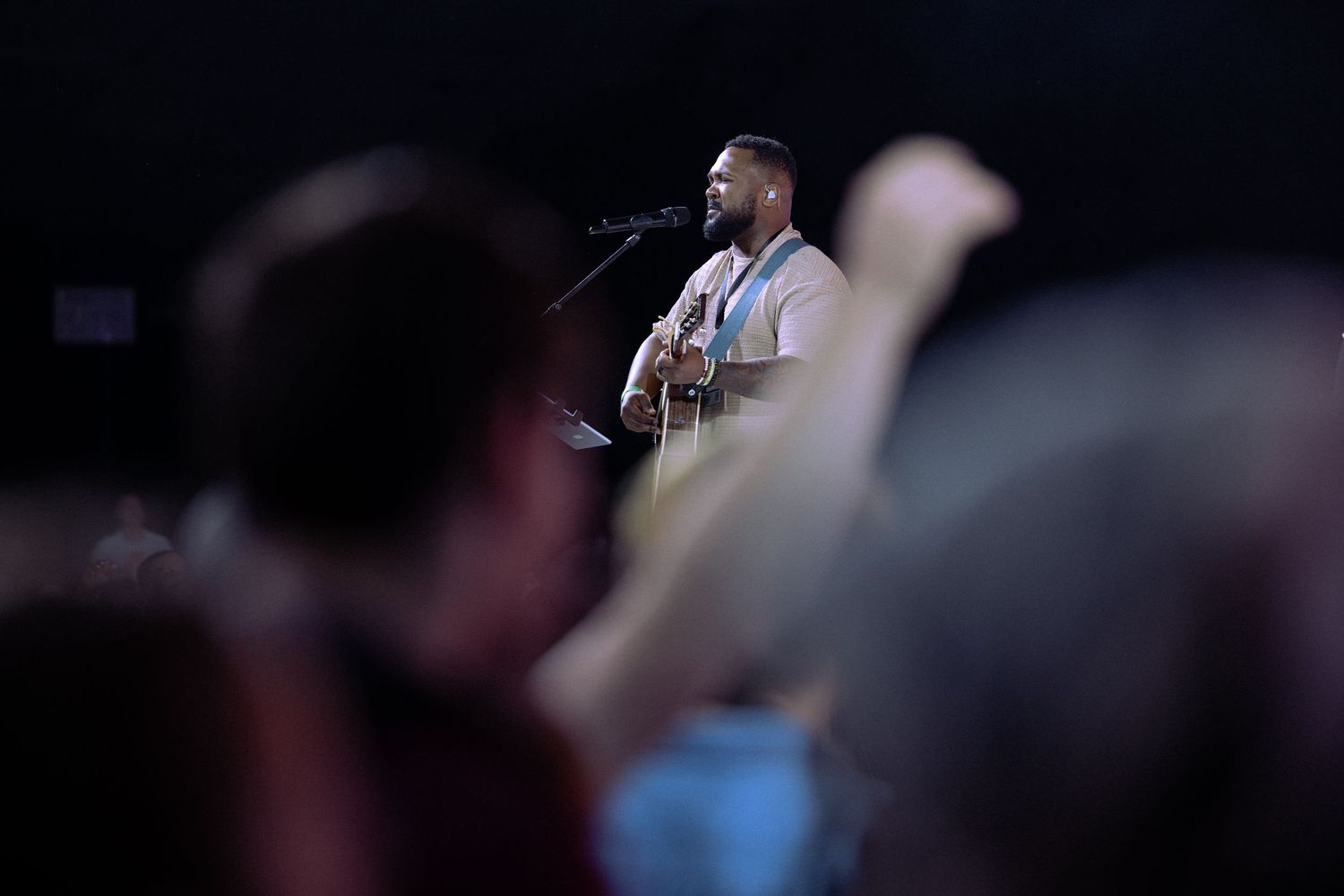 Performers on a dimly lit stage entertain a crowd during a live music concert.