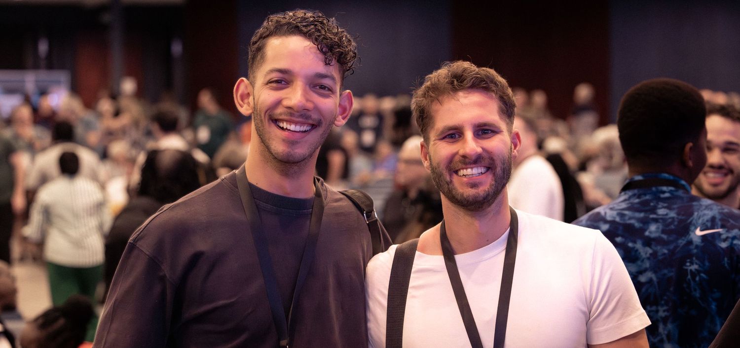 A group of people smiling and laughing together at a social gathering or event.