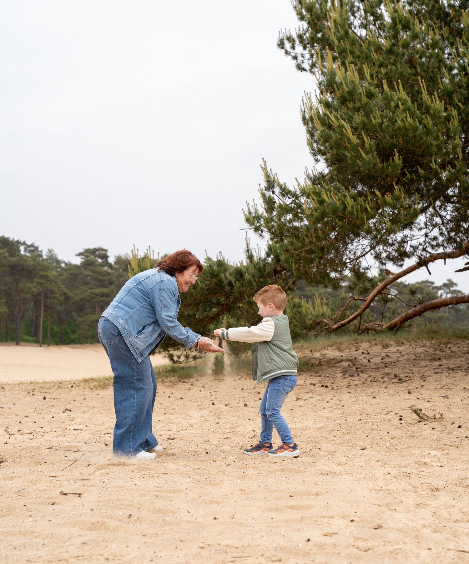 Samen met oma op de zandverstuiving in het zand spelen