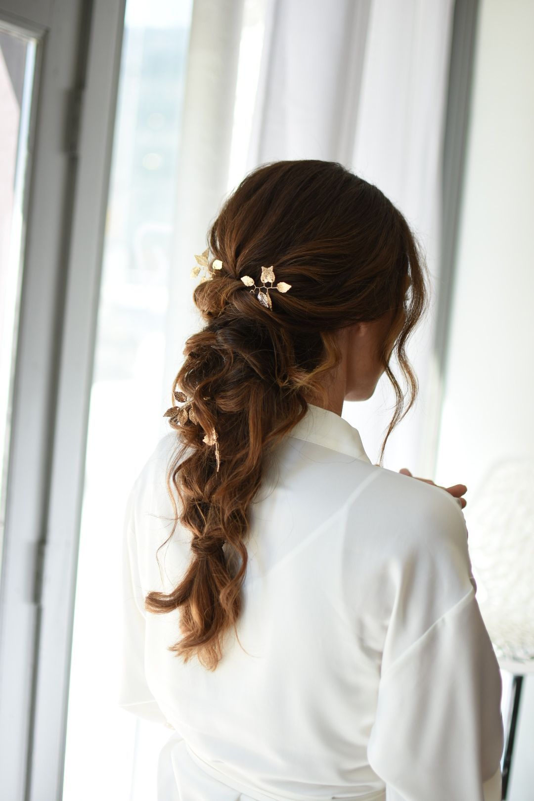 Bridal prep moment featuring an elegant braid with floral details captured in soft natural light before a Nashville wedding.