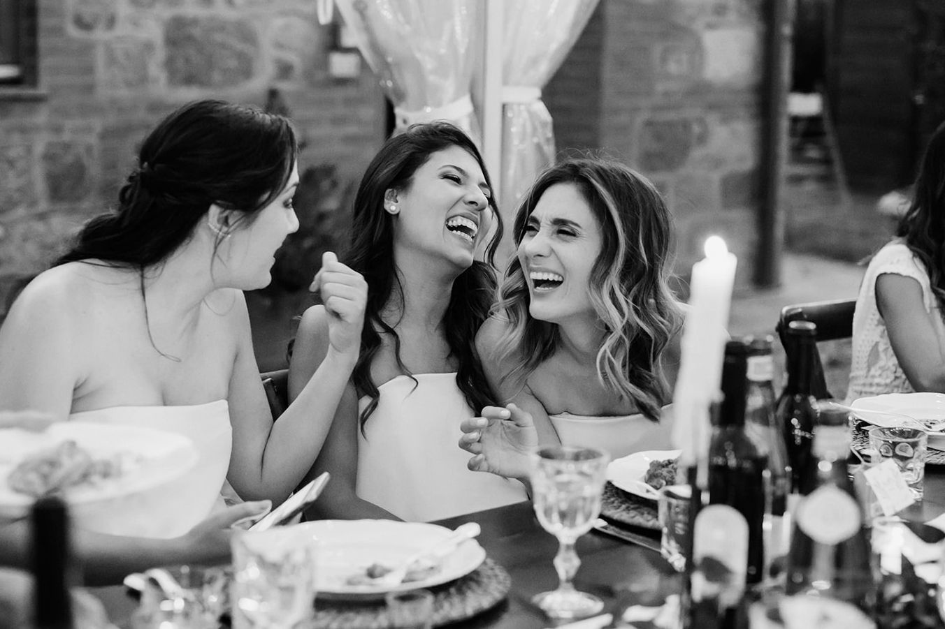 A black and white photo collage of candid moments at a wedding reception with guests dining and celebrating.