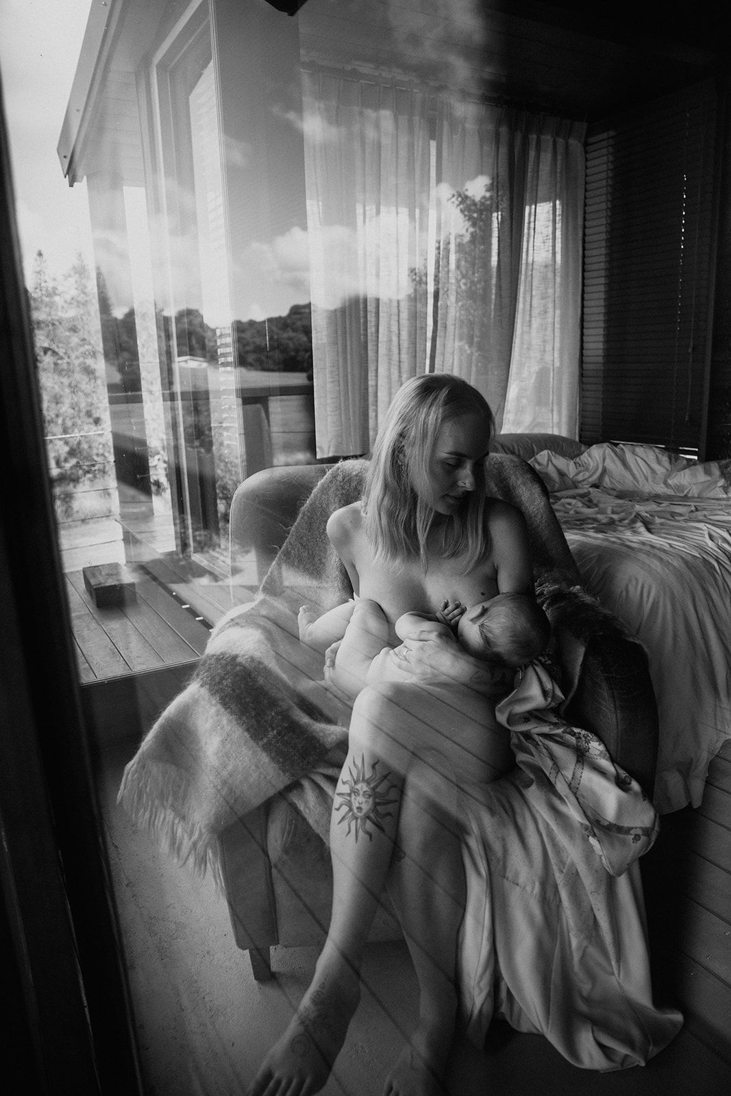 A series of black and white photographs showing intimate moments between figures resting on a bed near a window.