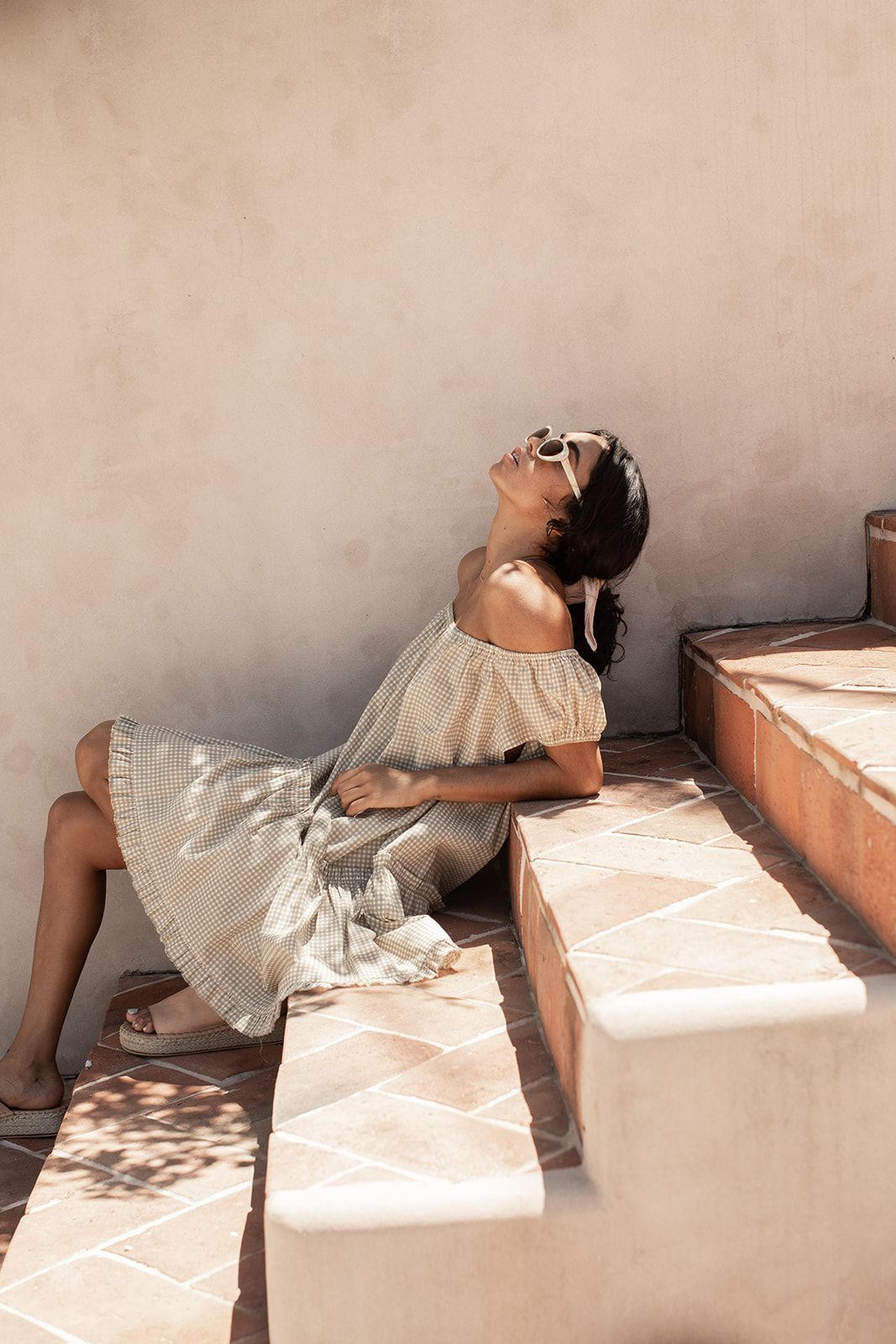 A sequence of photos showing someone in white clothing laying back on a pink surface in different positions.