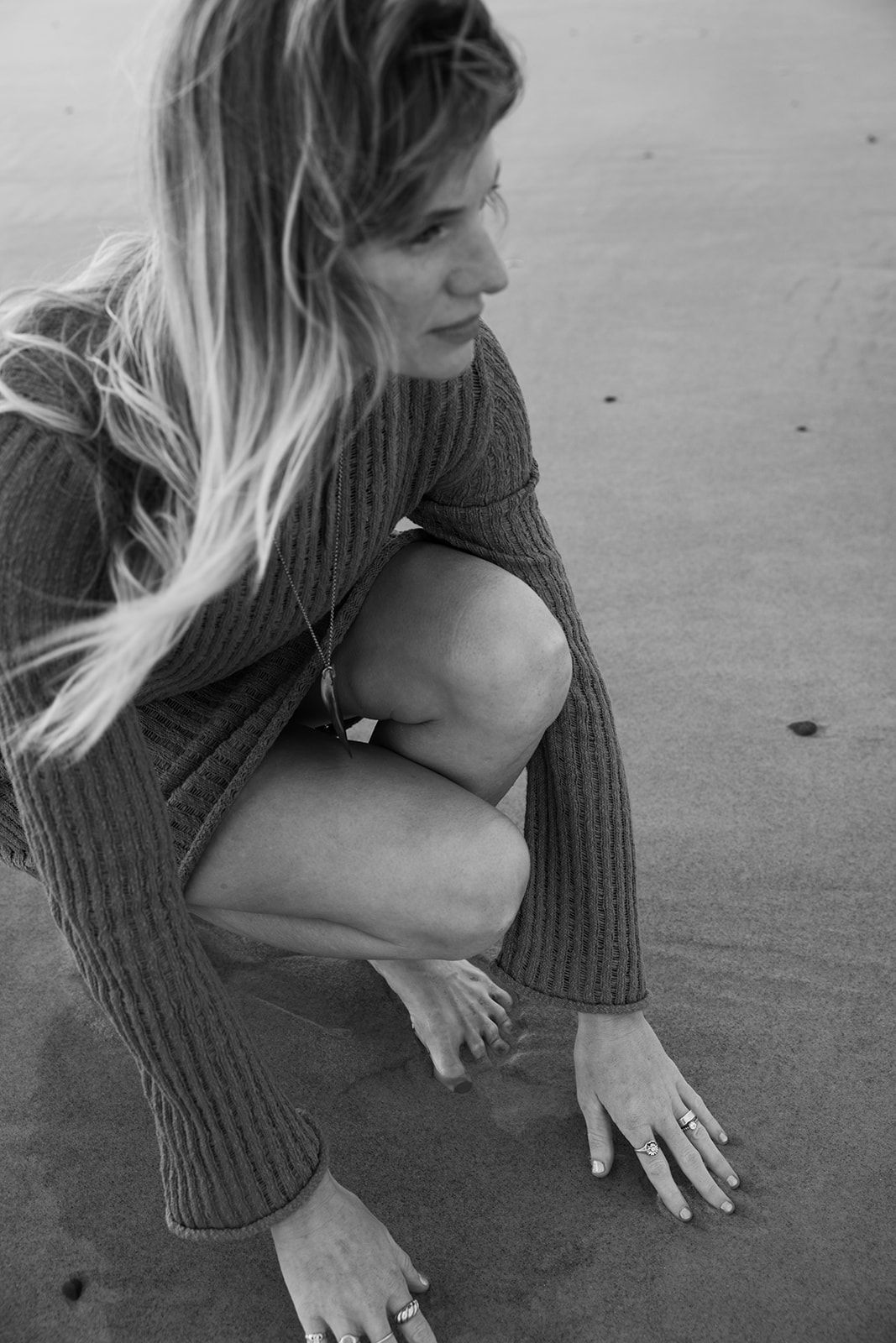 Black and white artistic photo series showing close-up details of someone in a ribbed sweater sitting on the ground.