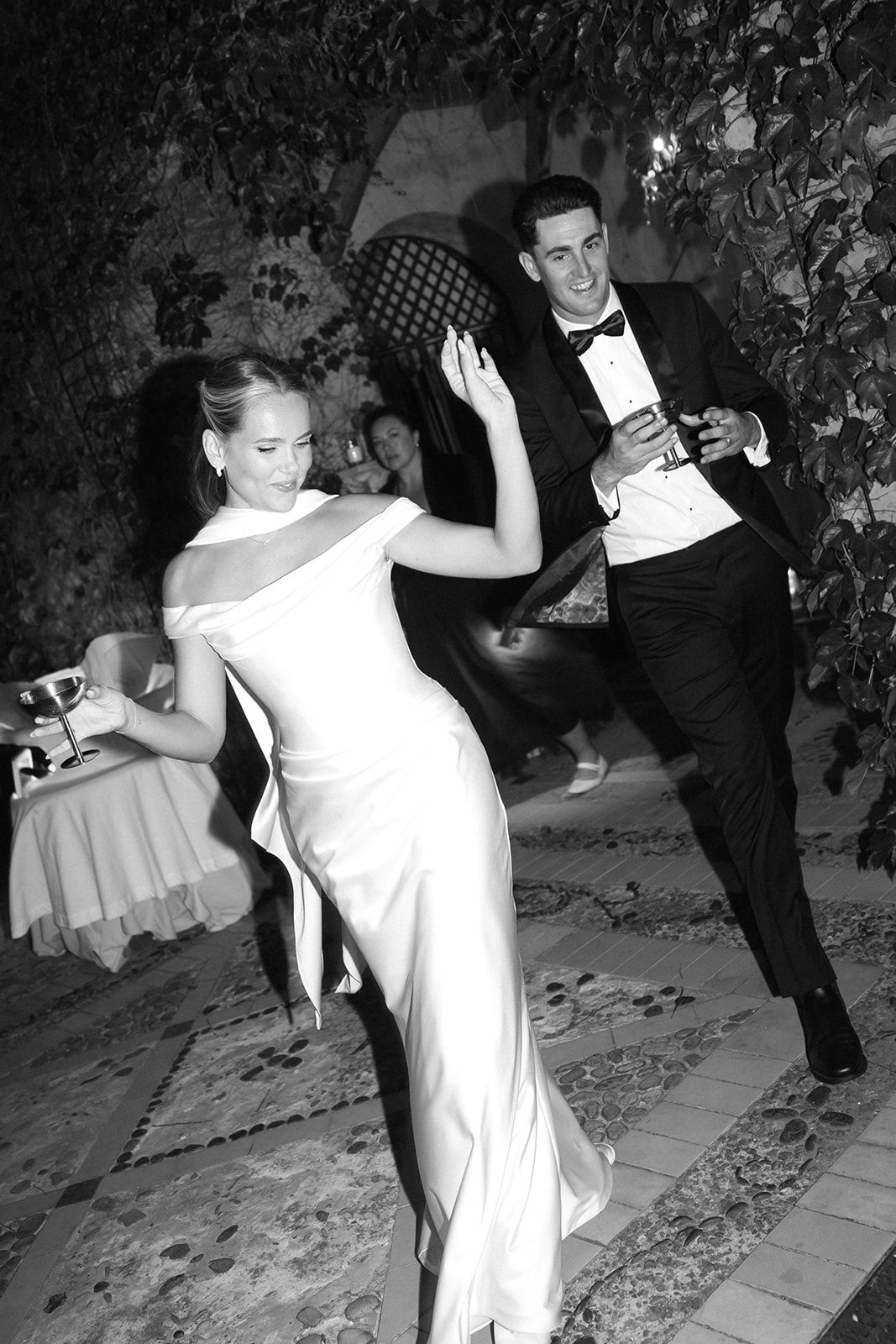 A sequence of black and white photos showing a couple dancing energetically at a formal event with twirls and spins.