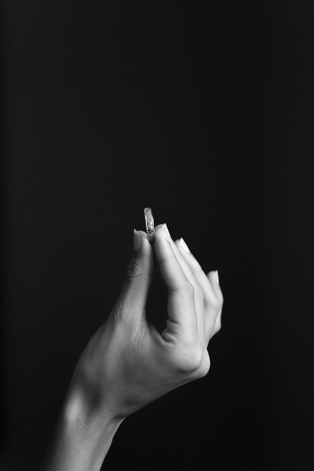 A sequence of black and white photos showing a hand making different gestures against a dark background.
