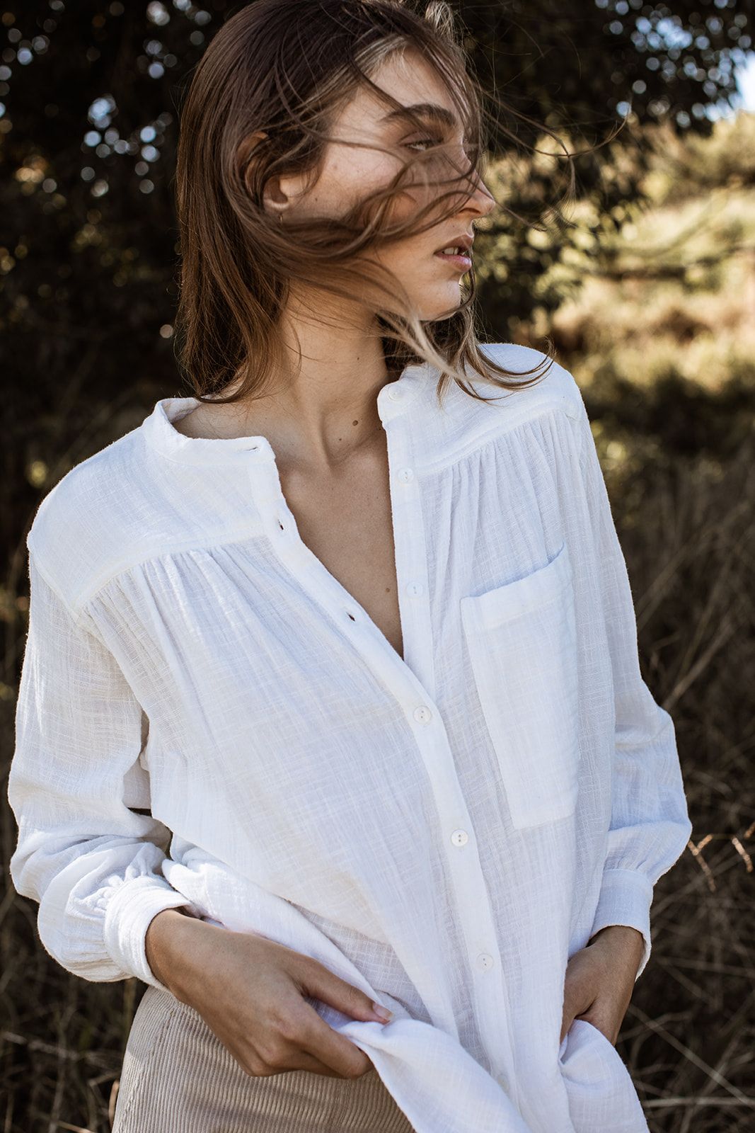 A series of artistic photos showing someone wearing a flowing white linen shirt against a natural outdoor backdrop.