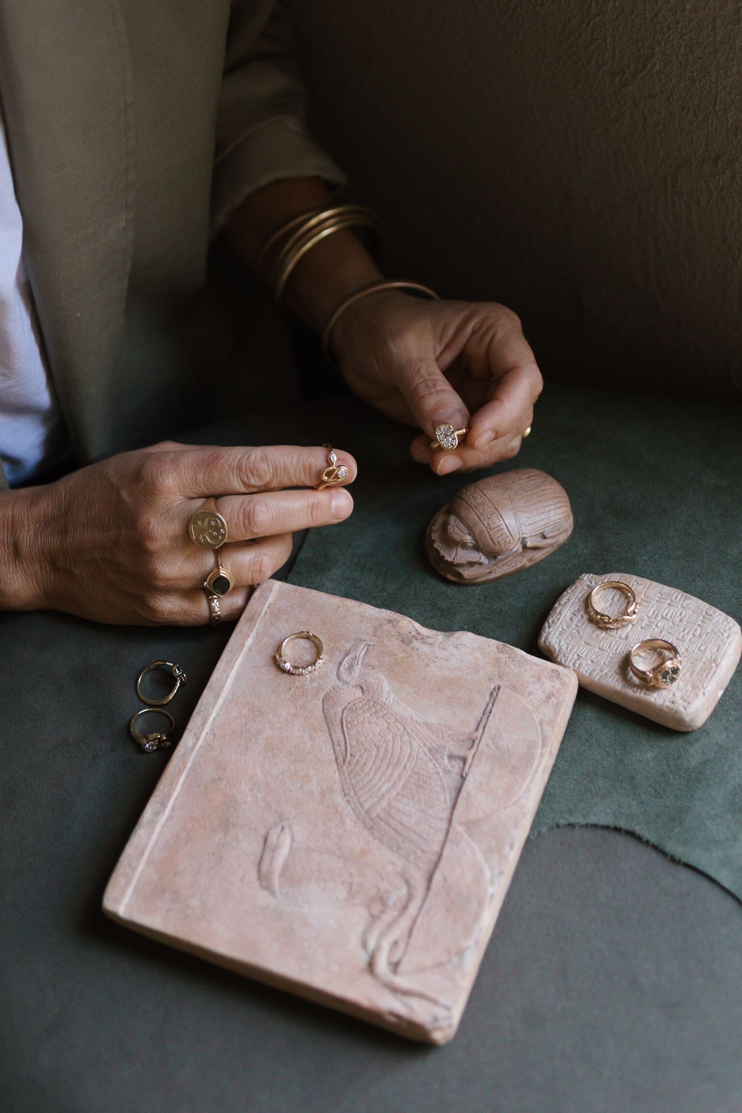 A sequence showing hands carving and sculpting a decorative clay tile with raised design elements and patterns.