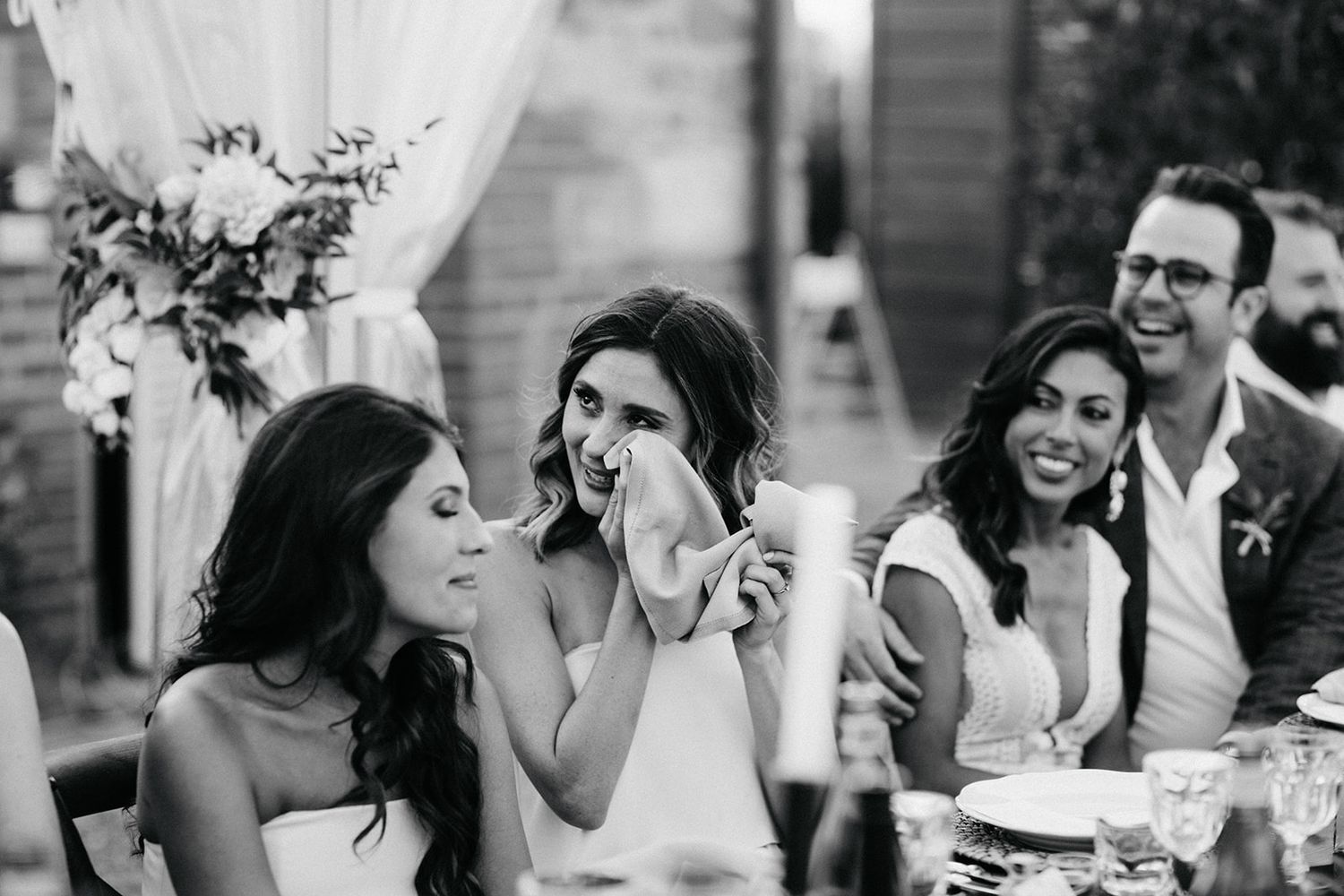 Series of black and white photos showing expressions of laughter and joy during an outdoor wedding reception.