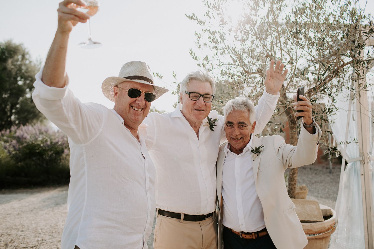 Group in white clothing celebrating and dancing together in a joyful outdoor celebration at sunset.