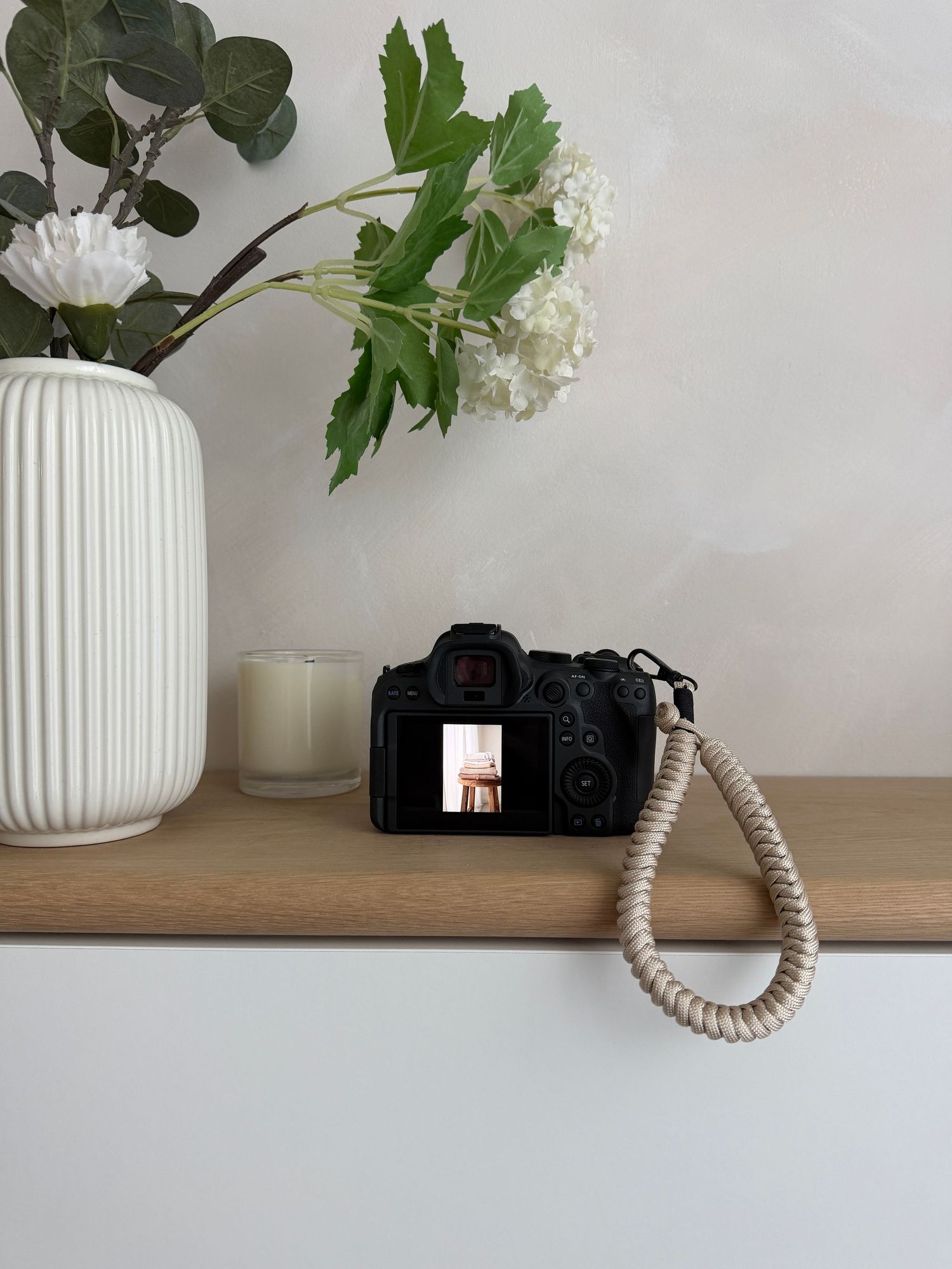 camera with wrist strap on wooden shelf  Nottingham newborn and family photographer natural cosy home studio