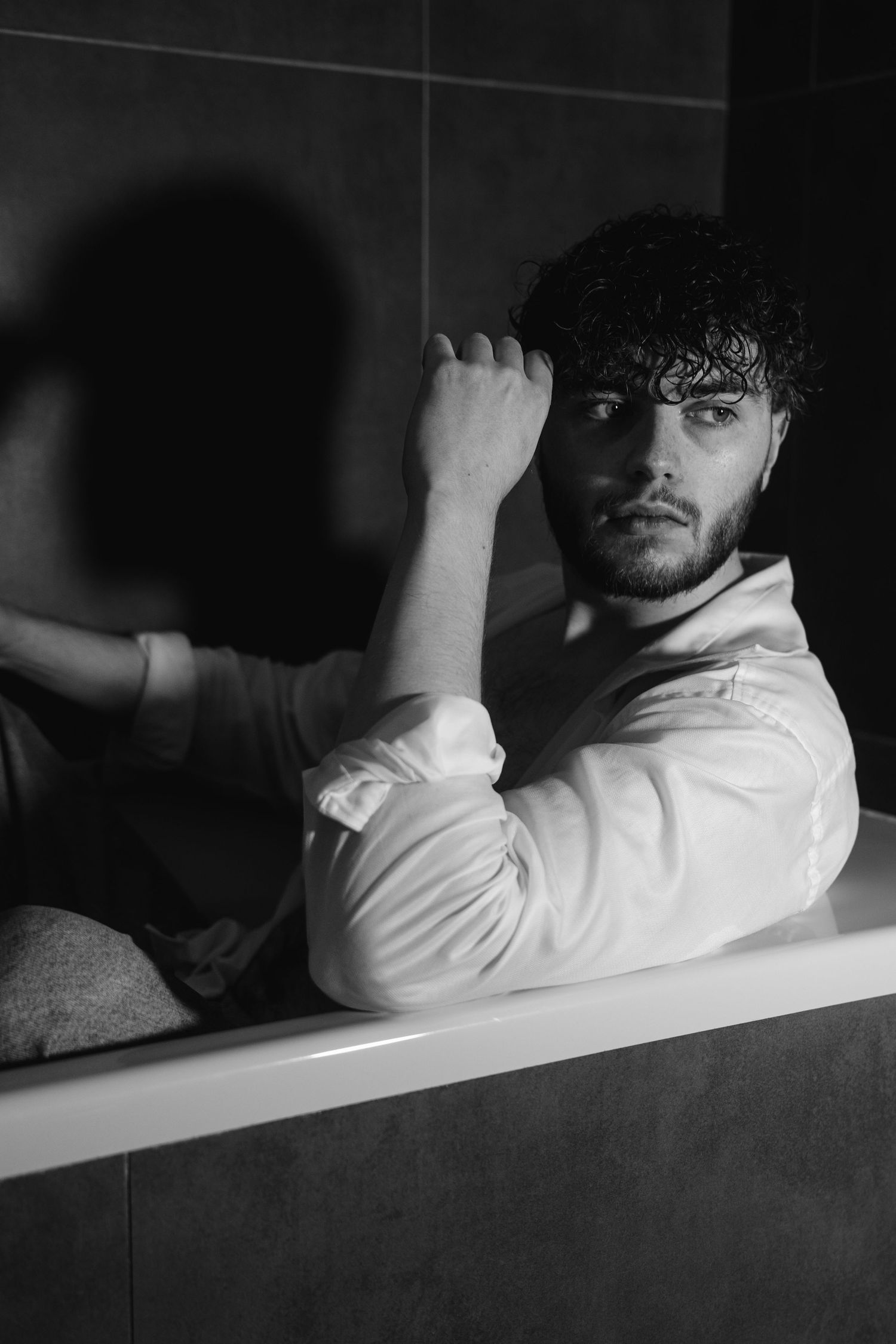 Photographie artistique d'un homme dans une ambiance élégante et intemporelle, capturant une expression naturelle.