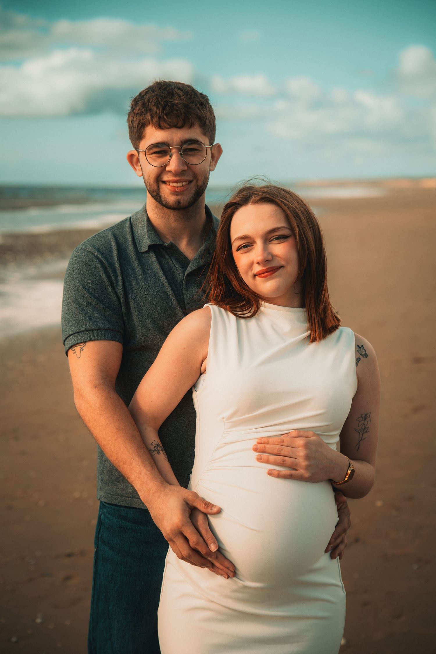 Séance grossesse sur la plage mettant en valeur la complicité des futurs parents dans un cadre naturel et lumineux.