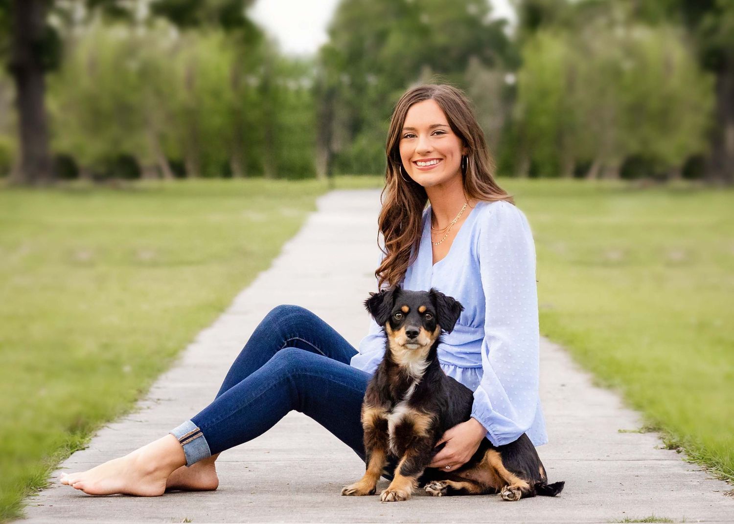 High school senior girl and her dog posing for senior portraits.