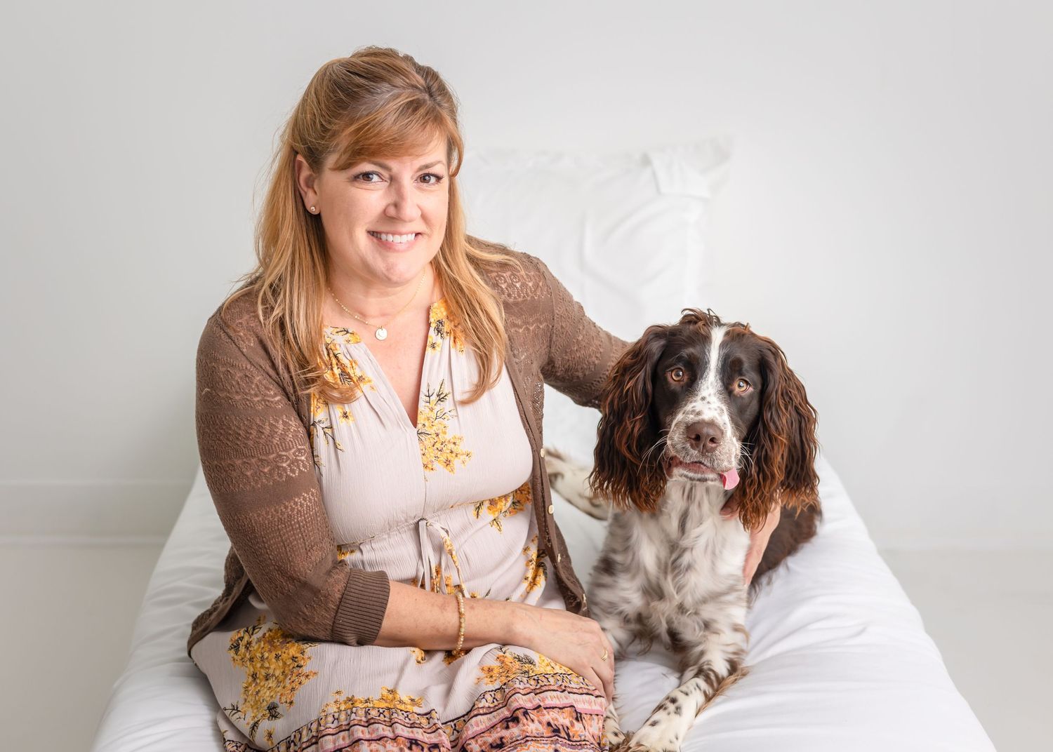 English Springer Spaniel and owner relaxing together in a bright white studio setting.