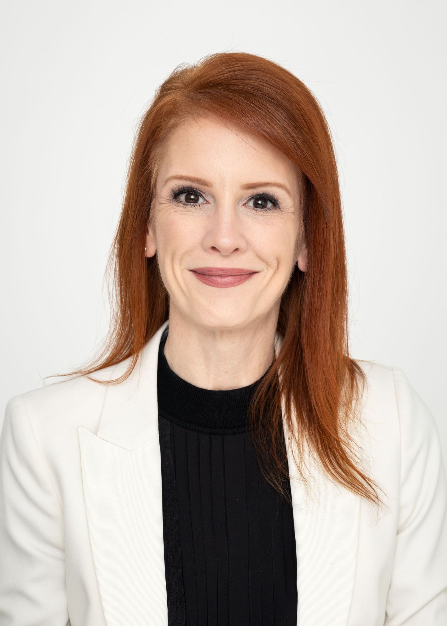 A series of headshots showing a person with red hair wearing a black turtleneck and white blazer against a white background.