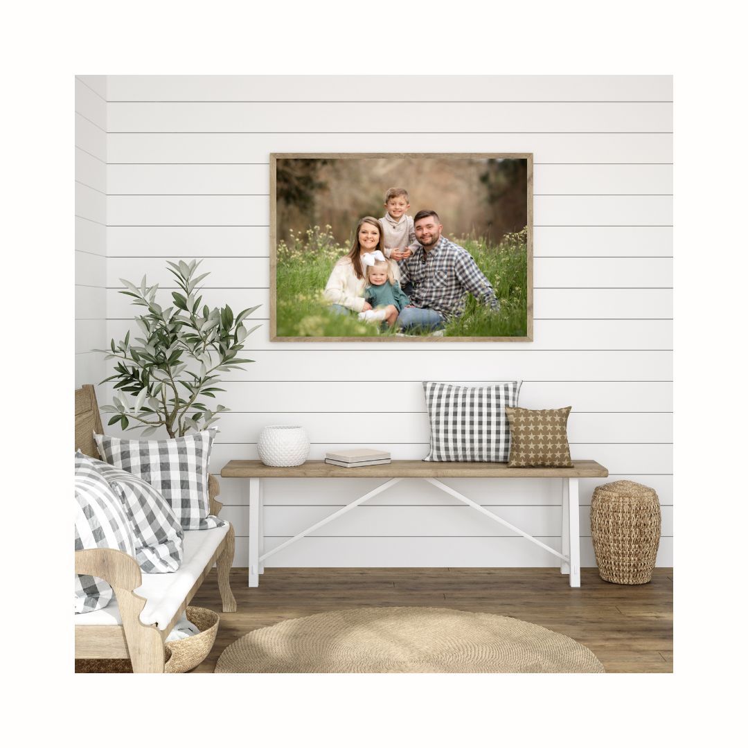 White farmhouse bench styled with gray pillows and decor against shiplap wall with framed artwork above.