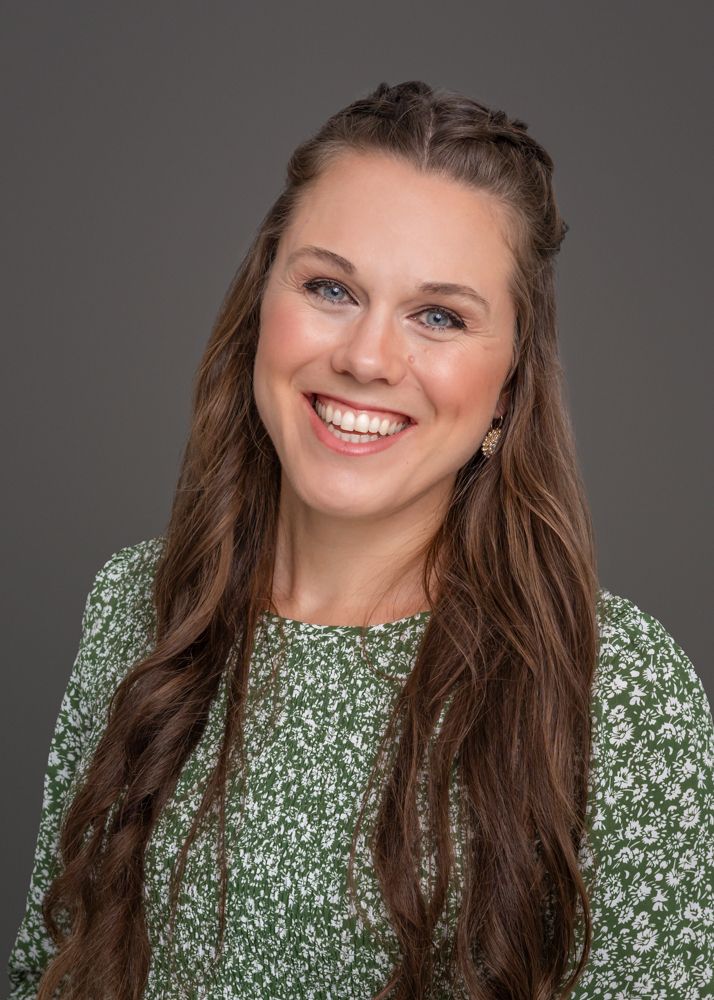 A series of four headshots showing someone wearing a green floral print top against a gray background.