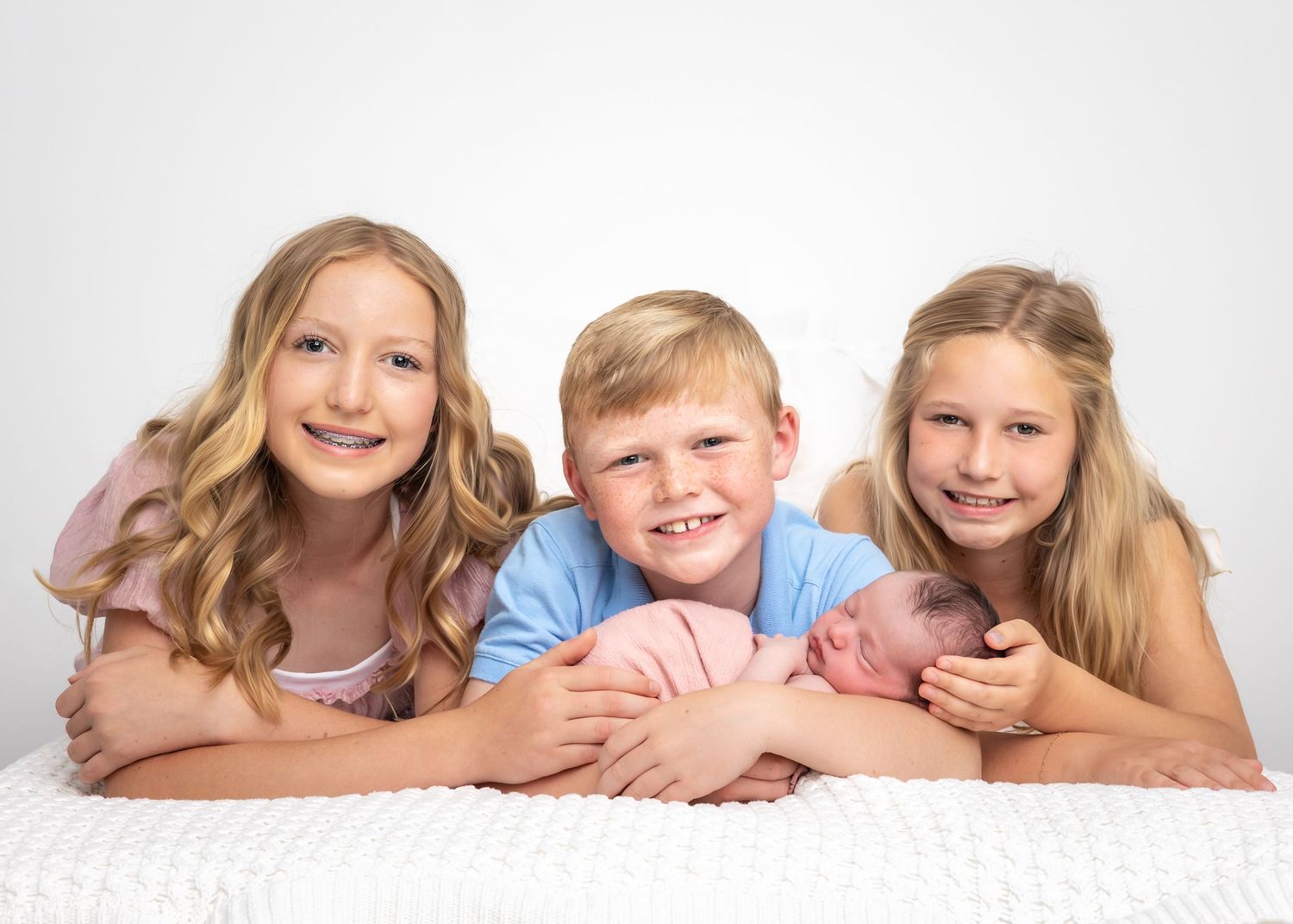 Studio portrait of siblings lying together on white background in casual attire.