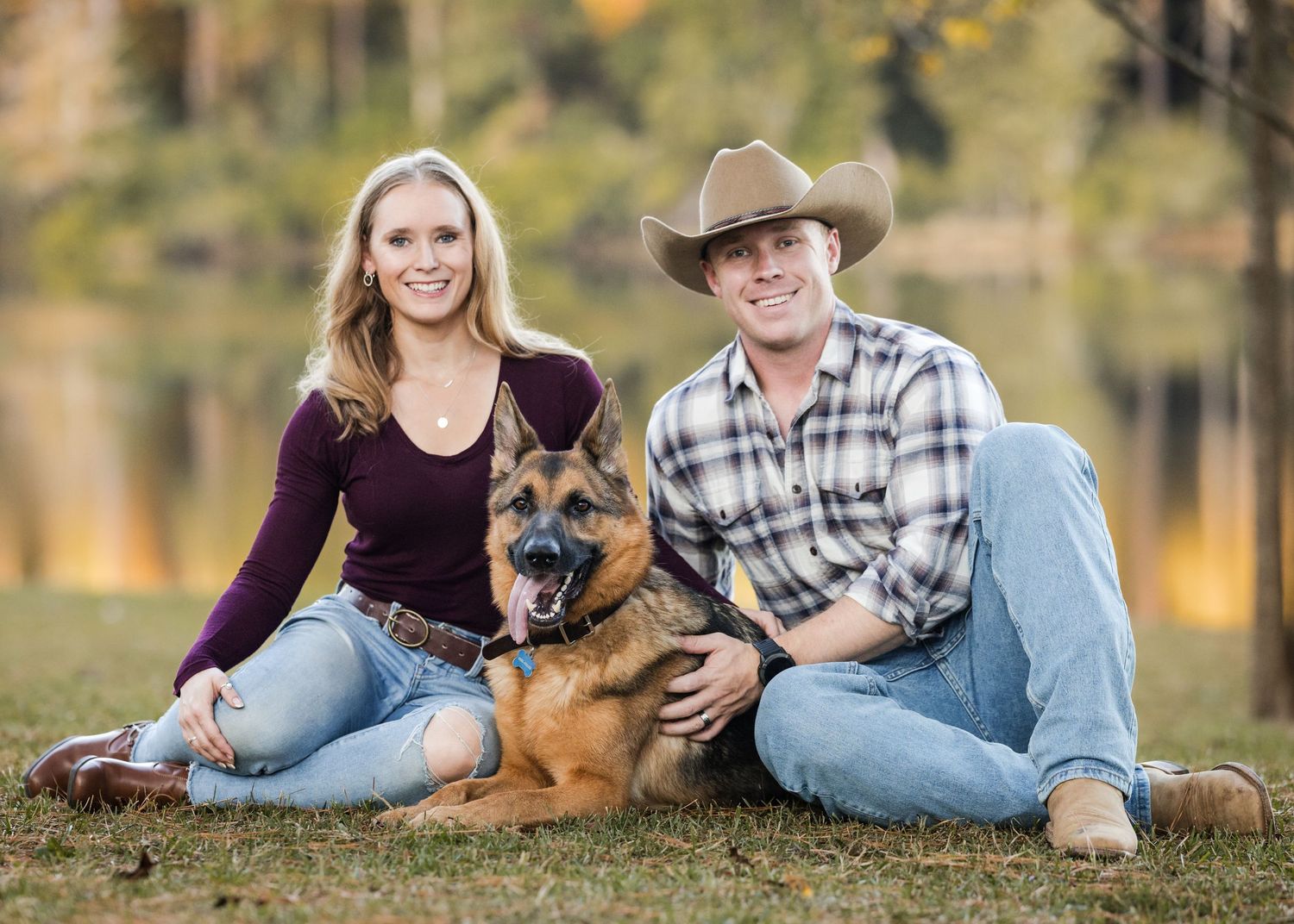 Casual outdoor photo session with couple and dog laying in autumn grass.