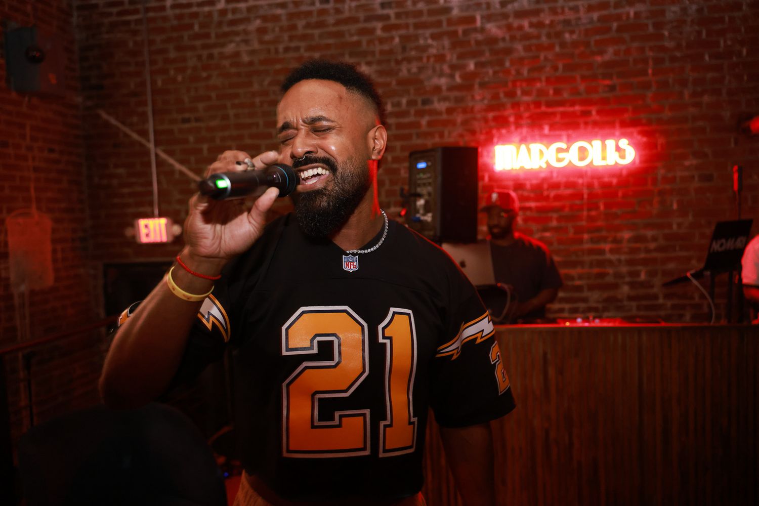 NBA players celebrating and laughing together at a bar with red neon lighting in the background.