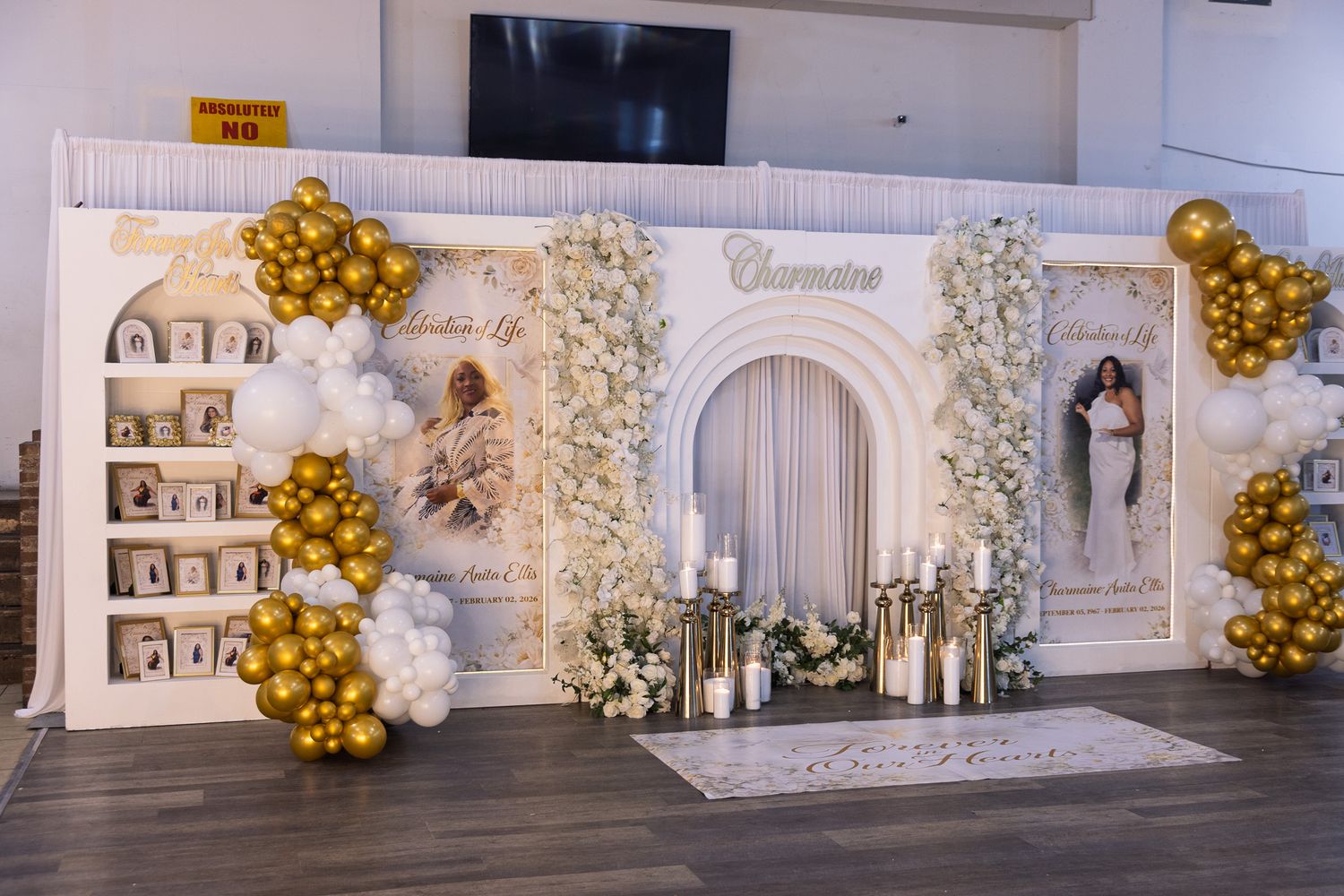 Elegant white and gold wedding reception venue with balloon arches and floral decorations along the walls.