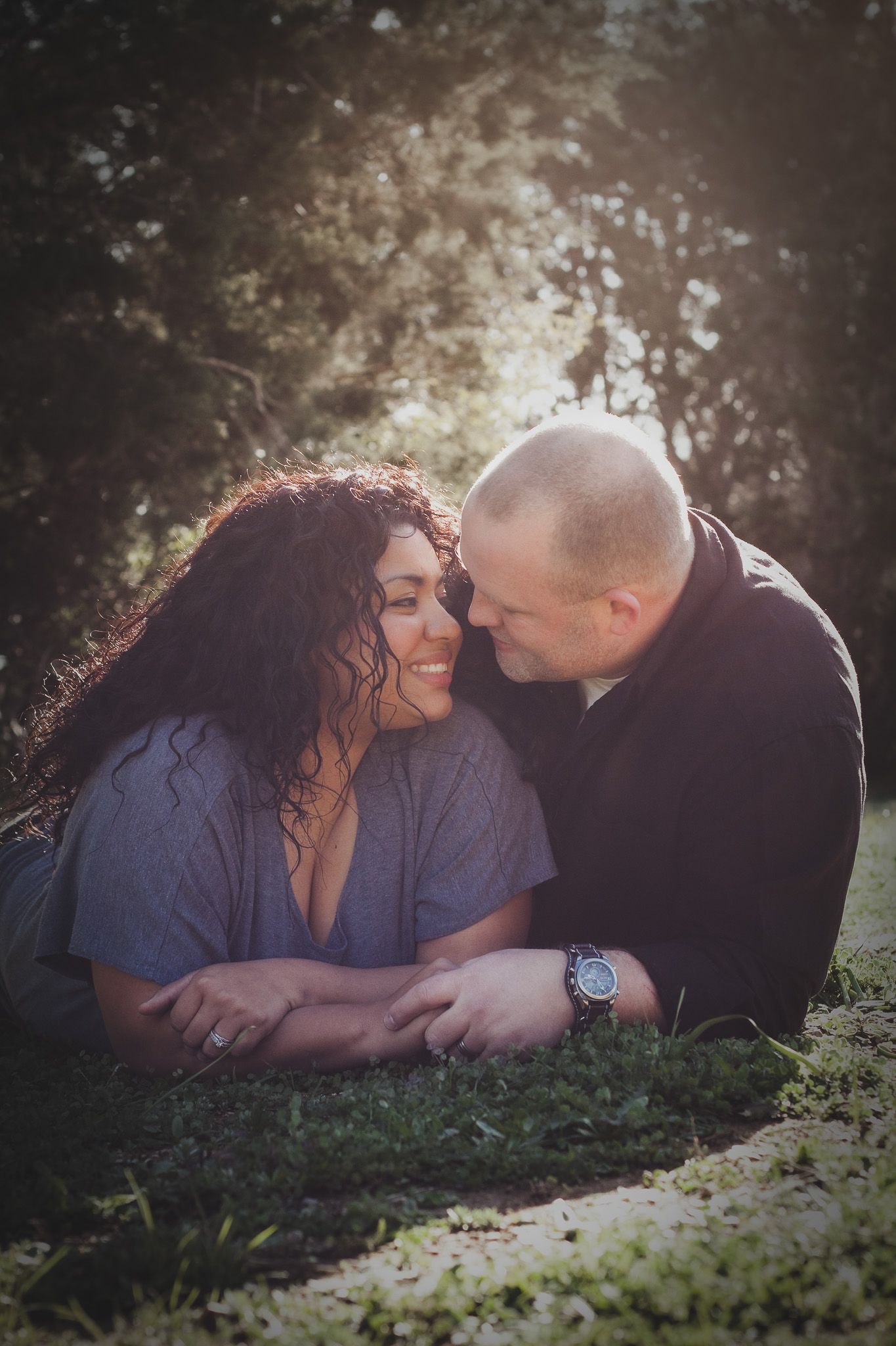 Couple gazing into each other's eyes in a grassy moment outdoors, moody natural light portrait session, Finger Lakes NY, Soft Wild LIght.