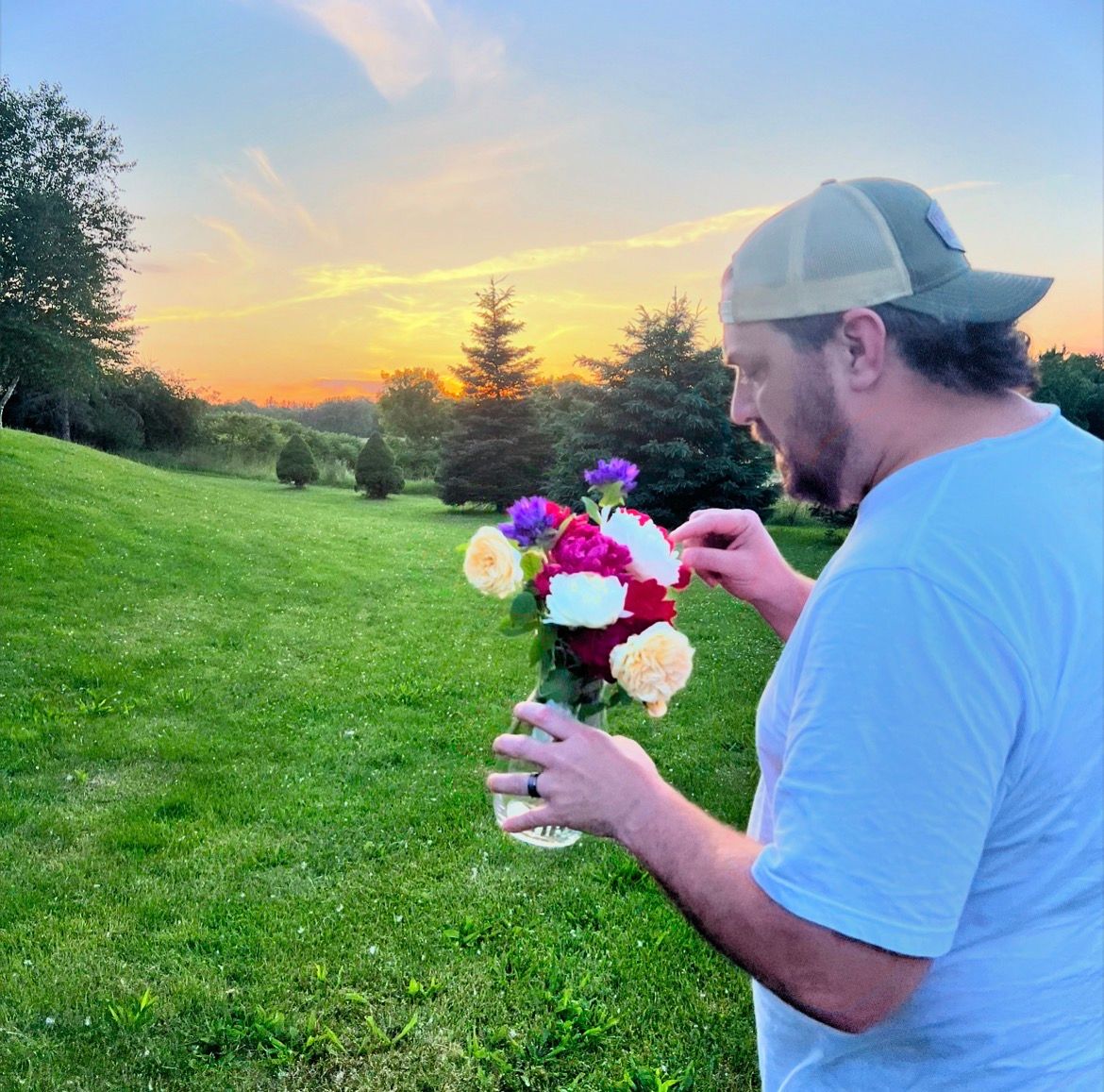 Man holding a bouquet of flowers at golden hour sunset, natural light outdoor portrait, Finger Lakes NY, Soft Wild Light Photography.