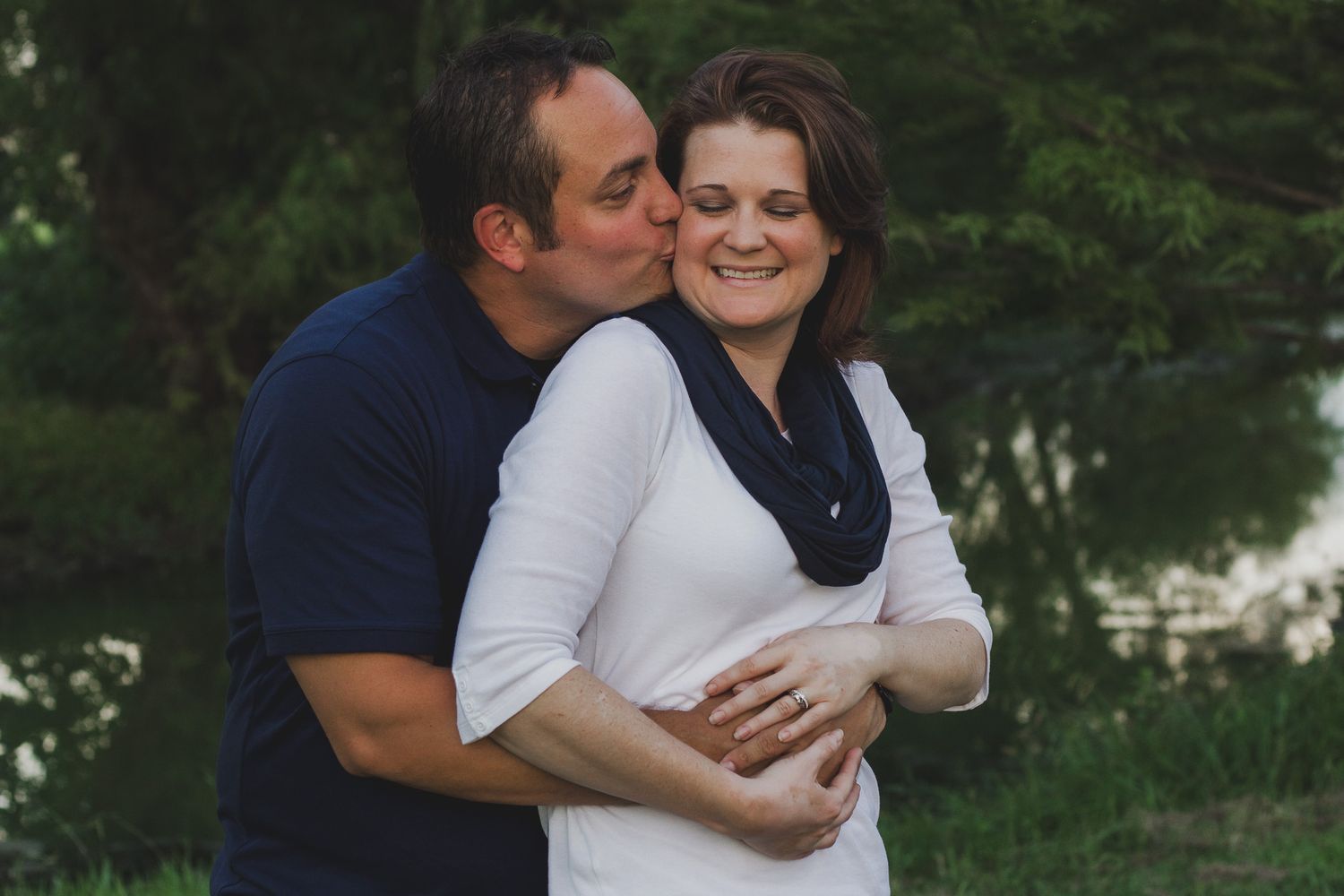 Couple embracing outdoors with man kissing woman's cheek, natural light portrait session, Finger Lakes New York, Soft Wild Light.