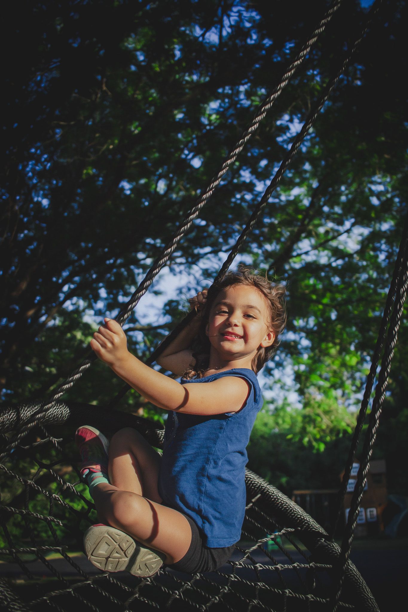 Young child laughing while swinging from a tree, candid outdoor portrait, Finger Lakes New York, Soft Wild Light Photography.
