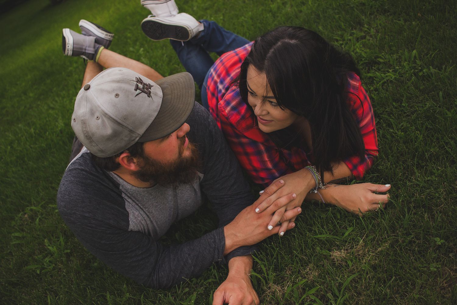 Couple laughing and holding hands together on the grass, candid family portrait session, Finger Lakes NY, Soft Wild Light.