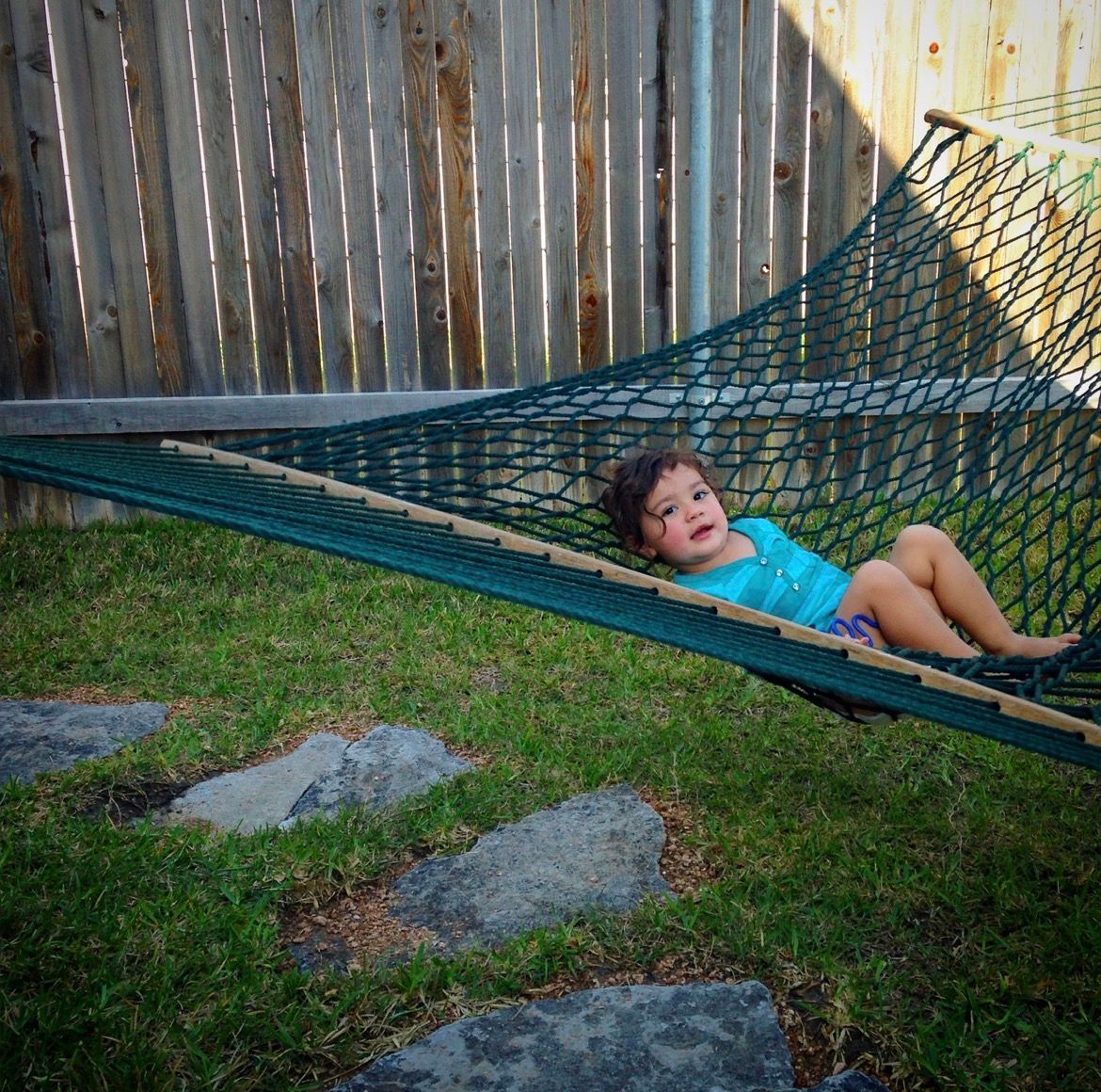 Young child relaxing in a backyard hammock, candid outdoor portrait session, Finger Lakes New York portrait photography.