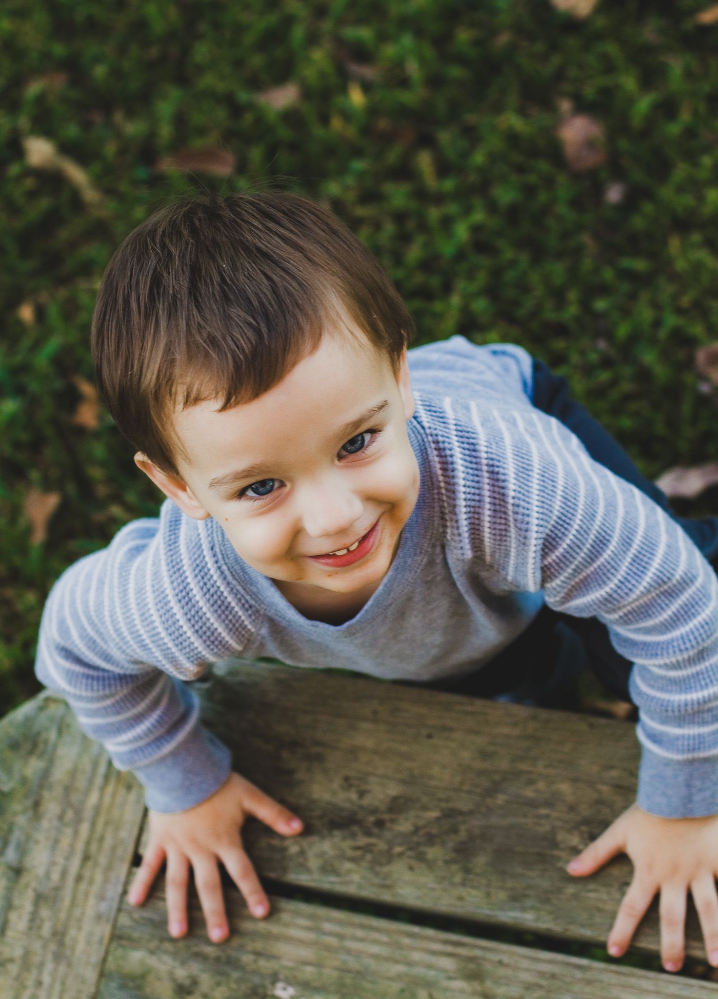 Playful toddler leaning over a wooden surface and smiling, candid child portrait, Finger Lakes New York, Soft Wild Light Photography