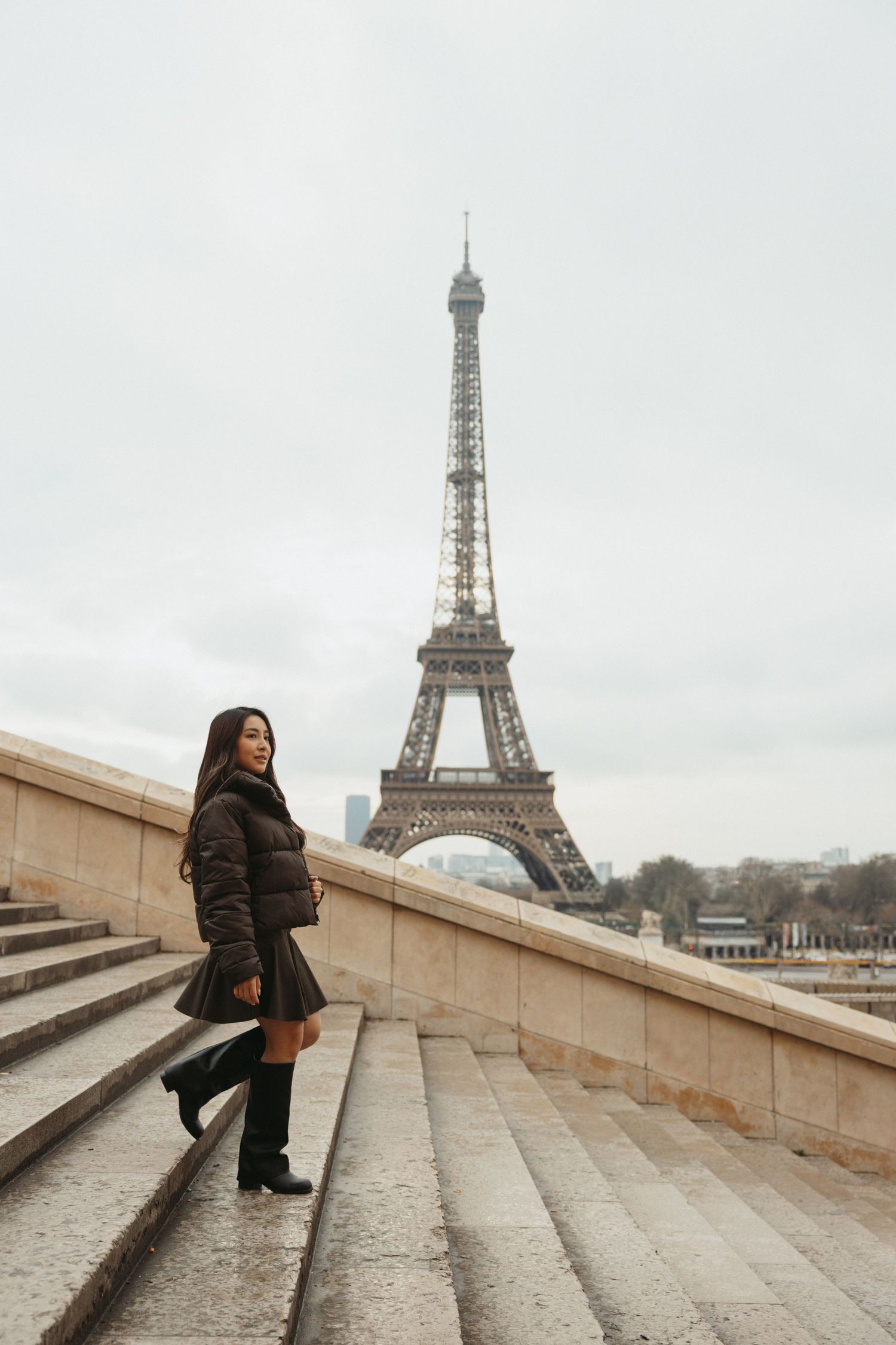 A series of photos showing someone posing on stone steps with the iconic Eiffel Tower in Paris visible in the background.