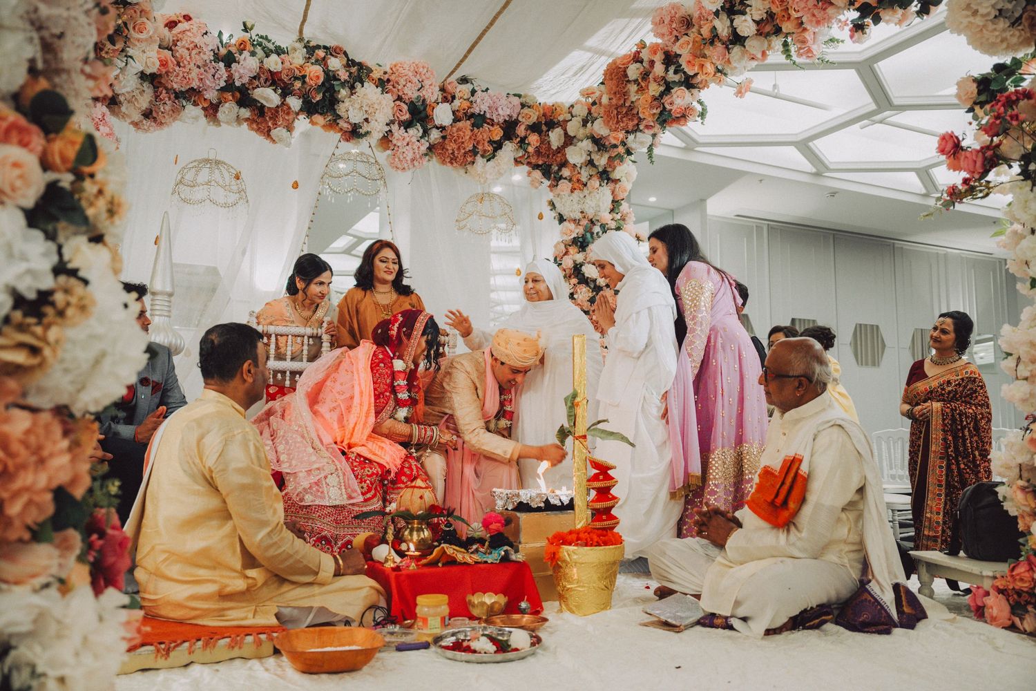 Traditional Indian wedding ceremony with decorative floral arrangements and cultural rituals being performed.