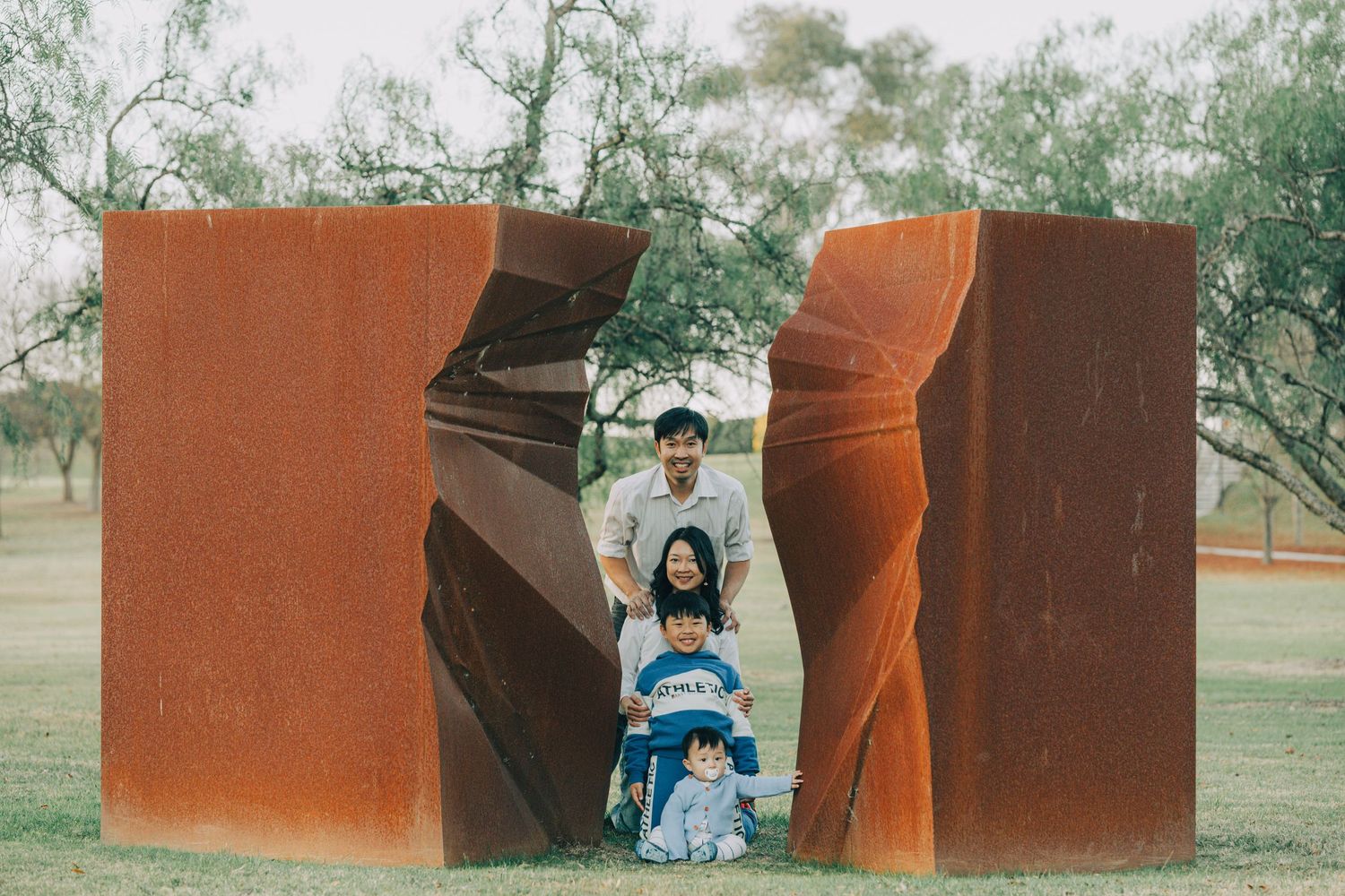 Modern rustic metal sculpture installation in outdoor park setting.