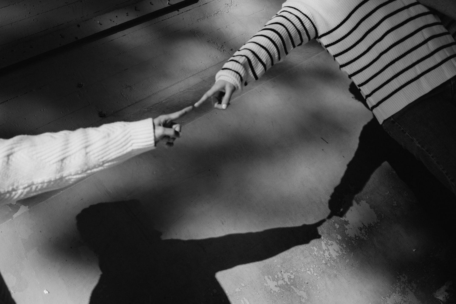 Black and white photograph of a hand holding a sharp knife against a dark background.