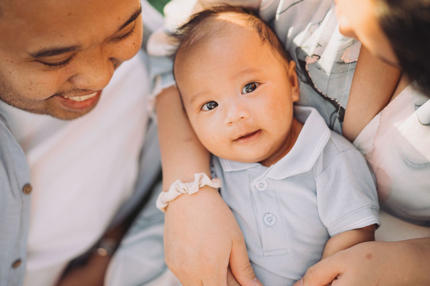 A parent and baby share tender moments in a series of intimate black and white photographs.