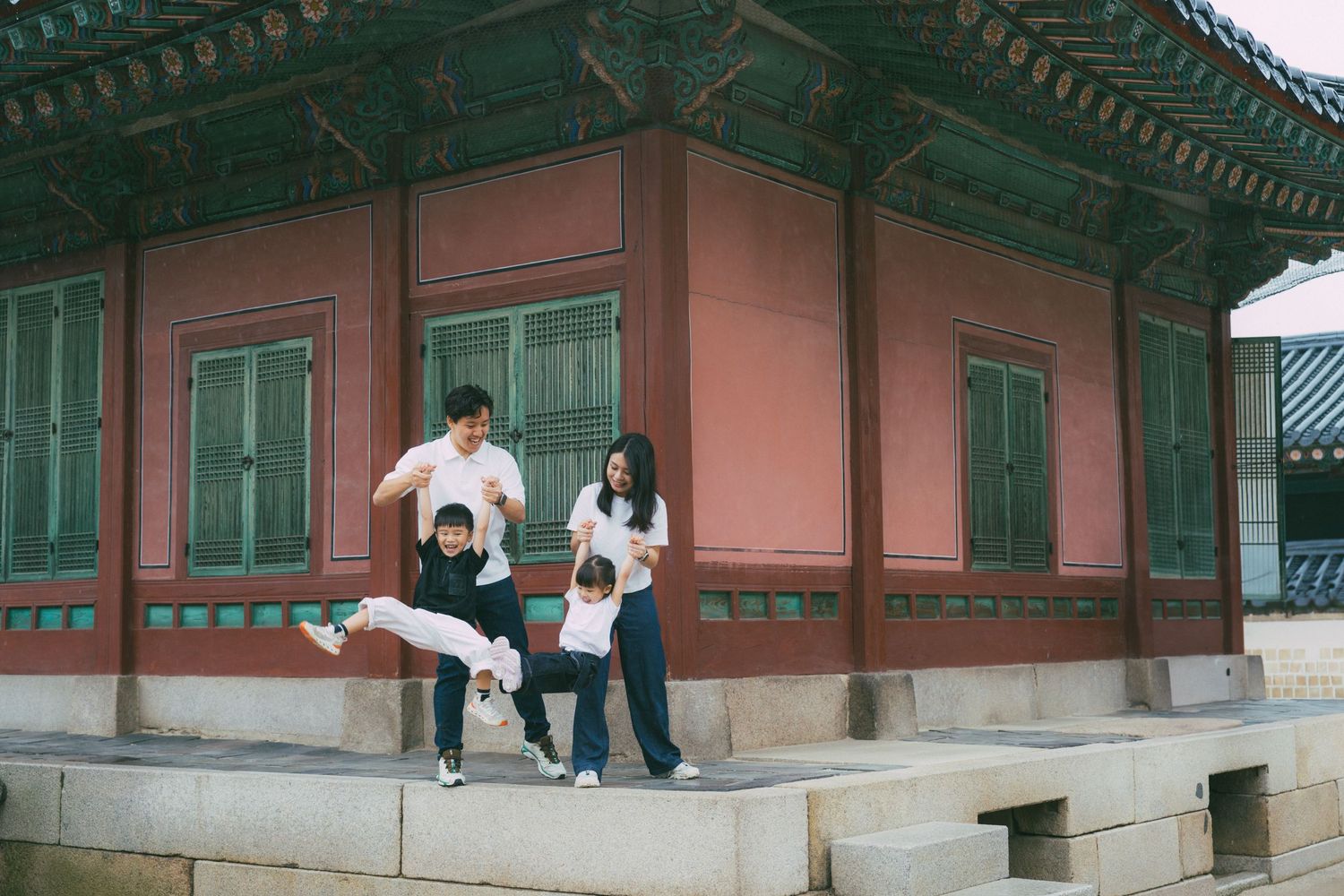 Visitors explore the traditional Korean palace architecture with ornate wooden buildings and stone pathways.