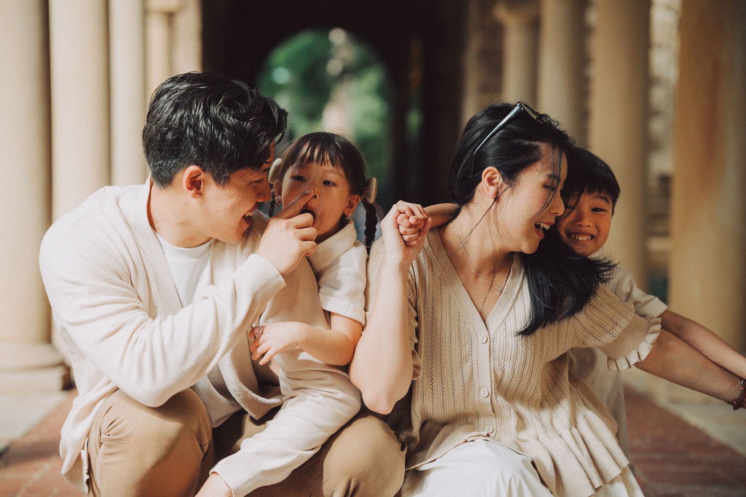 A series of candid moments showing a couple in white clothing laughing together in an outdoor corridor.
