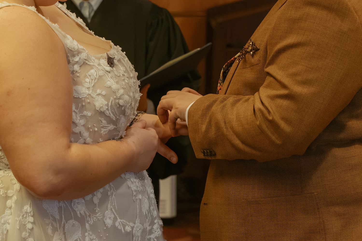 Close-up shot of a bride and groom signing their marriage license during a wedding ceremony.