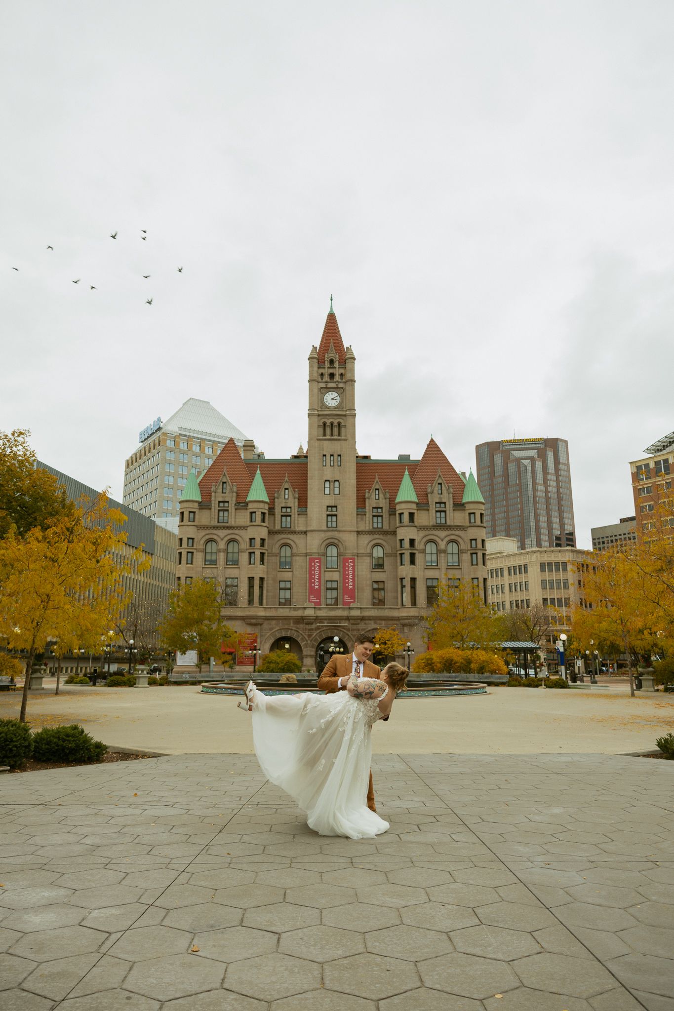 A series of photos showing a flowing white wedding dress spinning in front of a historic stone clock tower building.