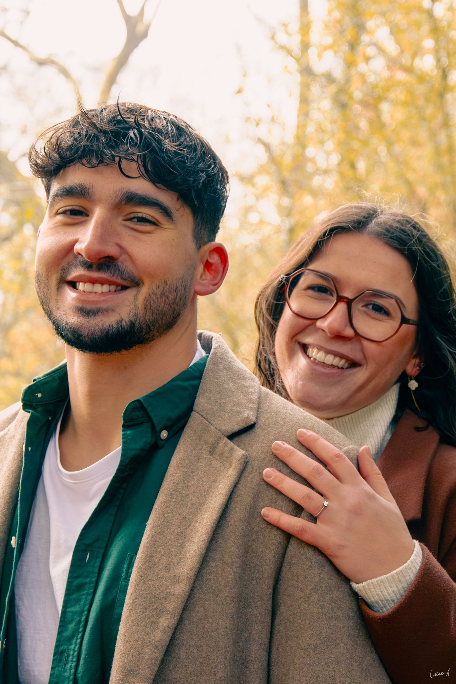 Prise couleur lors d'une séance d'engagement, la femme se tient derrière son fiancé, la tête sur l'épaule, la main tenant son bras, à Lille