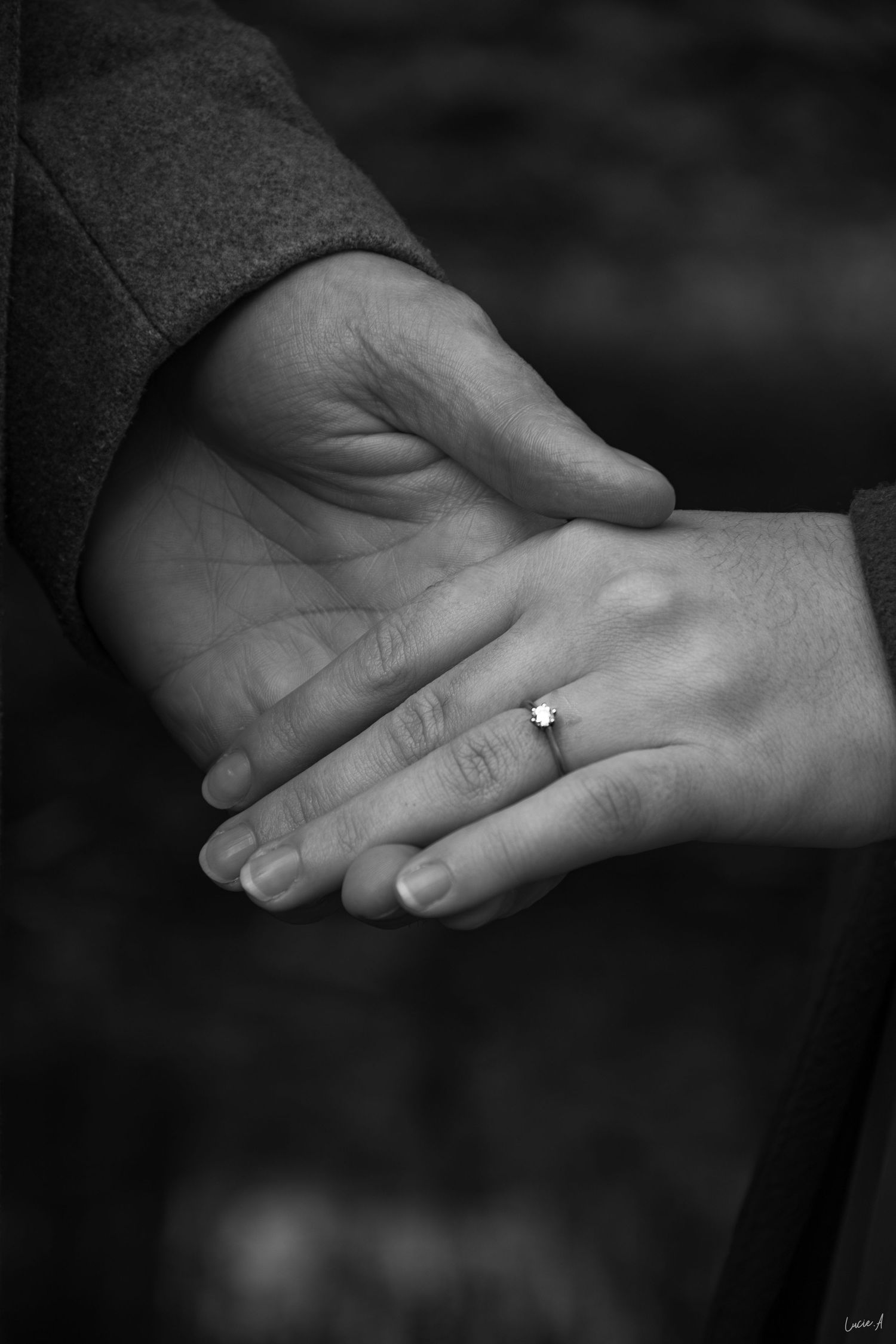 Séance d'engagement, noir et blanc, deux mains se touchant du bout des doigts, la bague de fiançaille mise en avant, à Lille