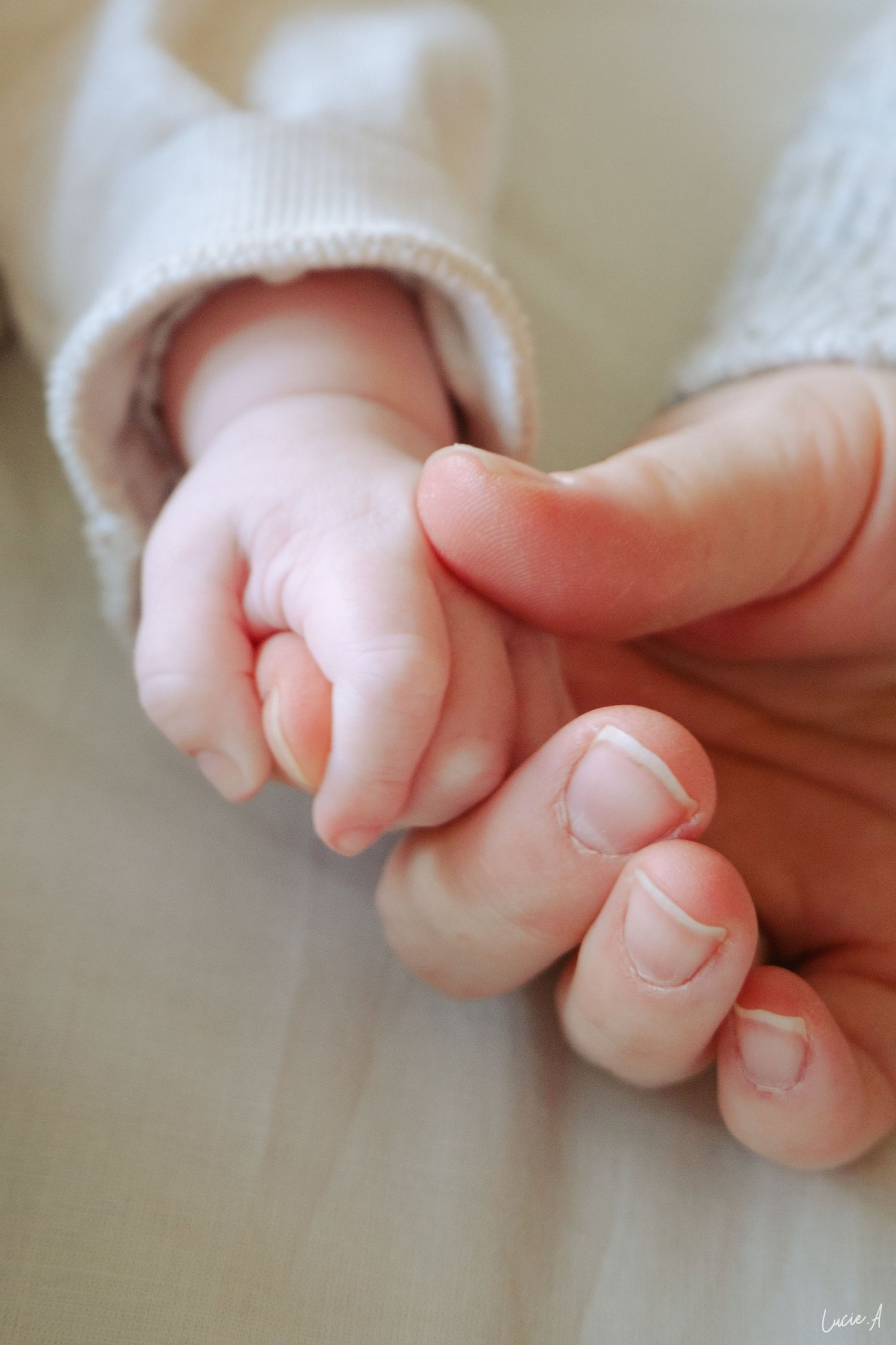 Plan rapproché de la main d'une maman tenant la main de son bébé