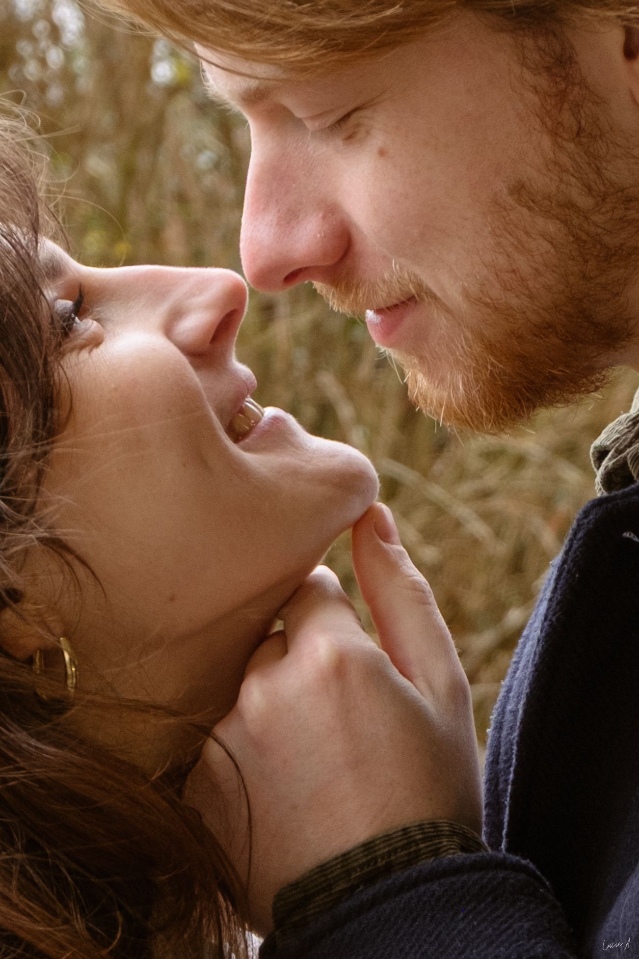 Portrait couple couleur, le couple se regard alors que l'homme relève le menton de sa compagne avec sa main, séance en extérieur à Ronchin