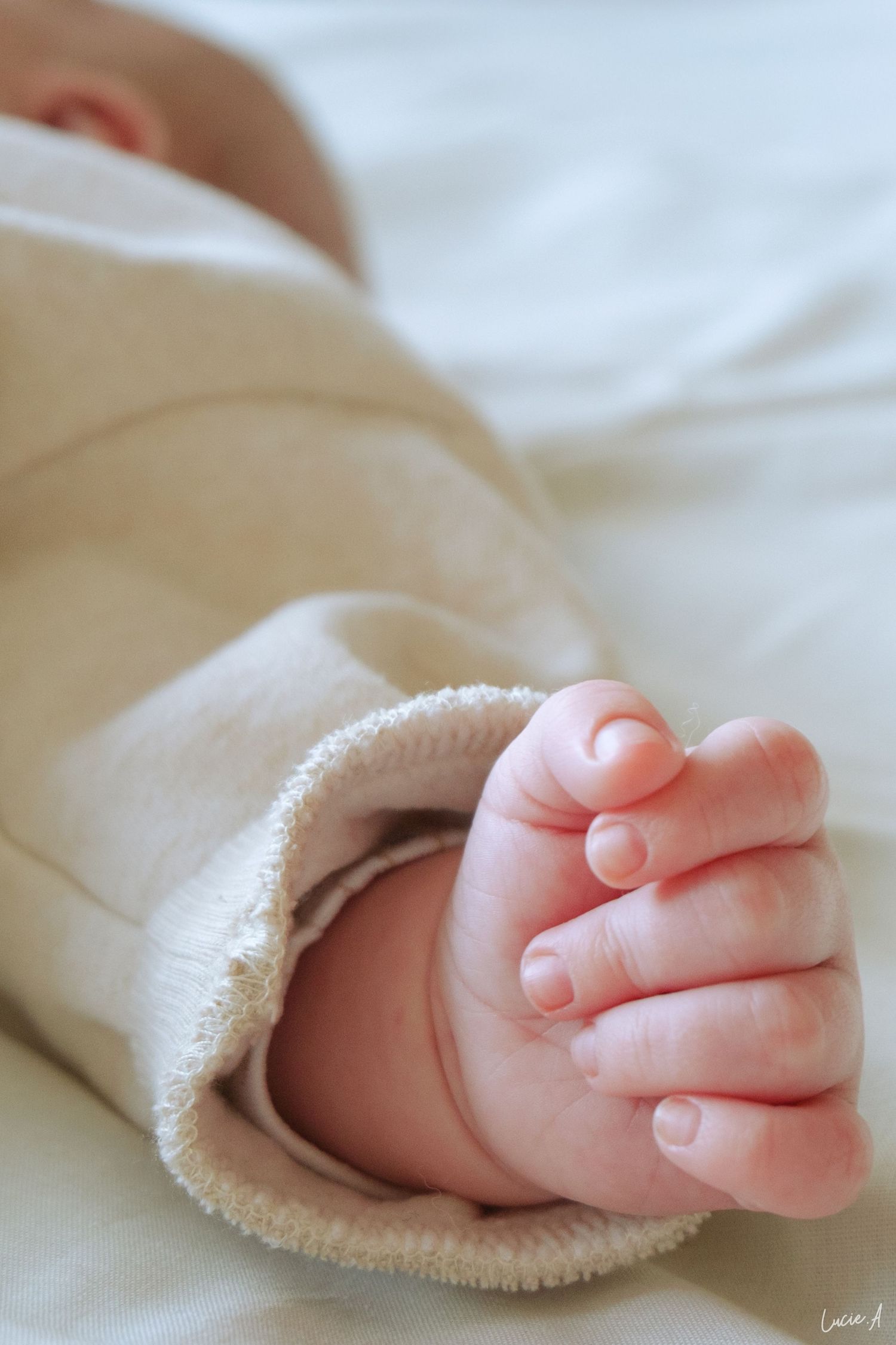 Plan rapproché de la main d'un bébé allongé sur son lit