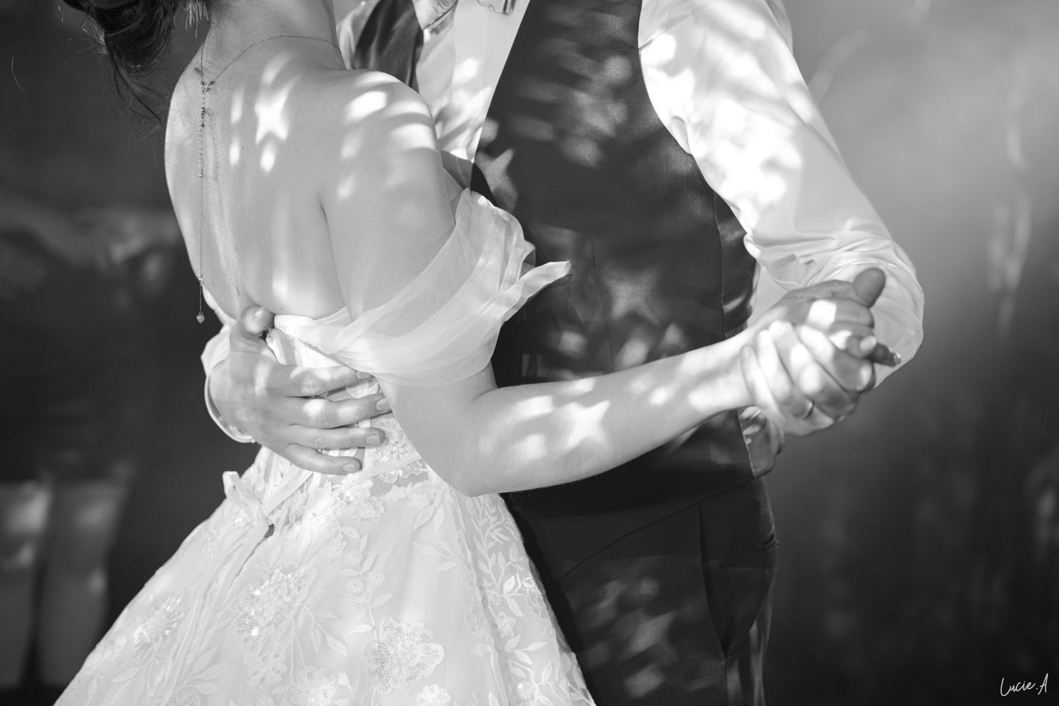 Gros plan romantique en noir et blanc des mariés partageant leur première danse lors de la réception de mariage.