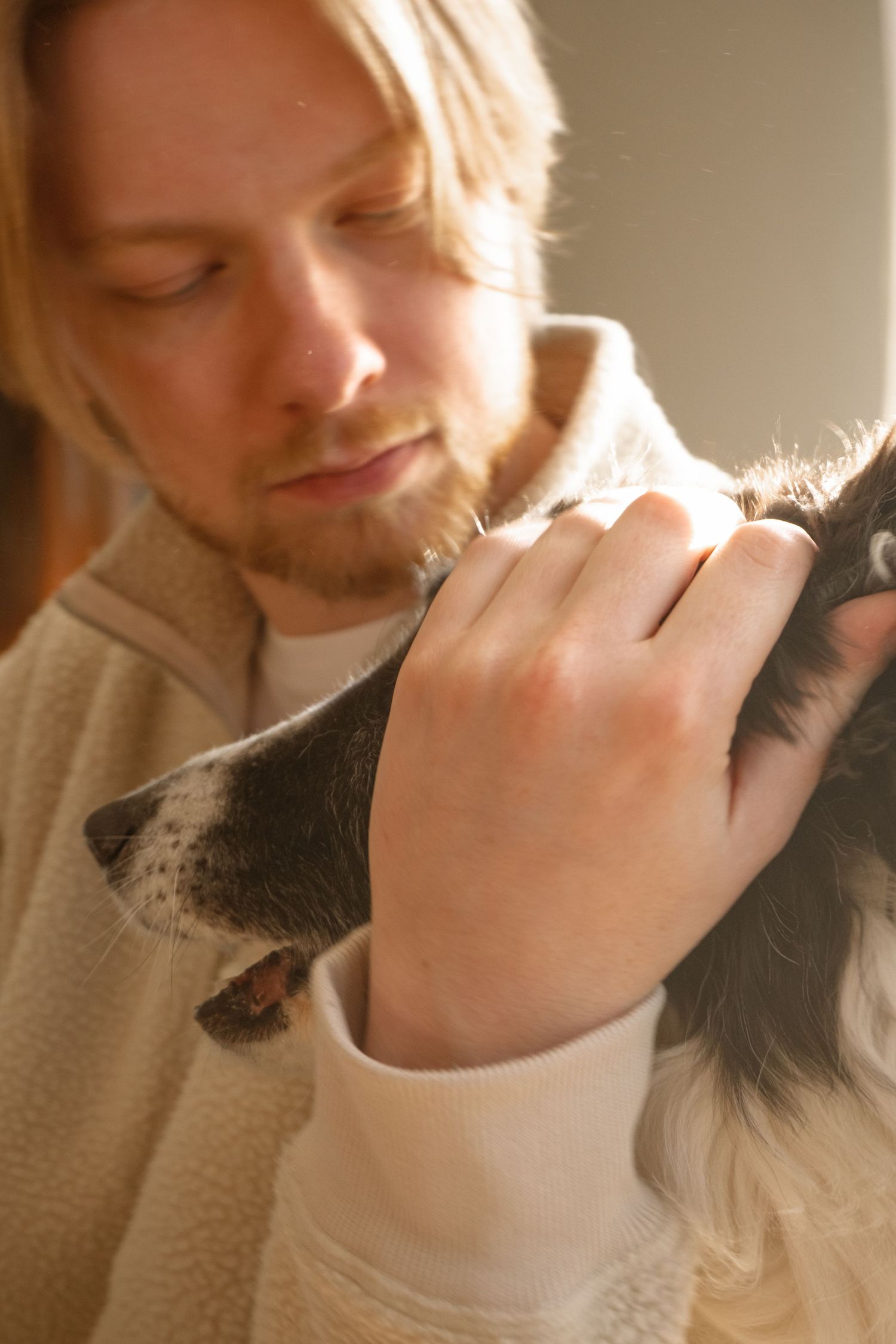 Portrait couleur entre un homme roux regardant son chien avec une main posée sur sa tête, capté à Ronchin