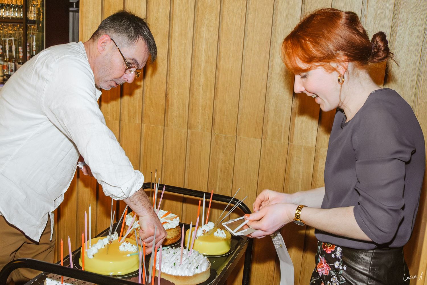 Deux personnes en train d'allumer des gateaux d'anniversaire, photo prise au flash